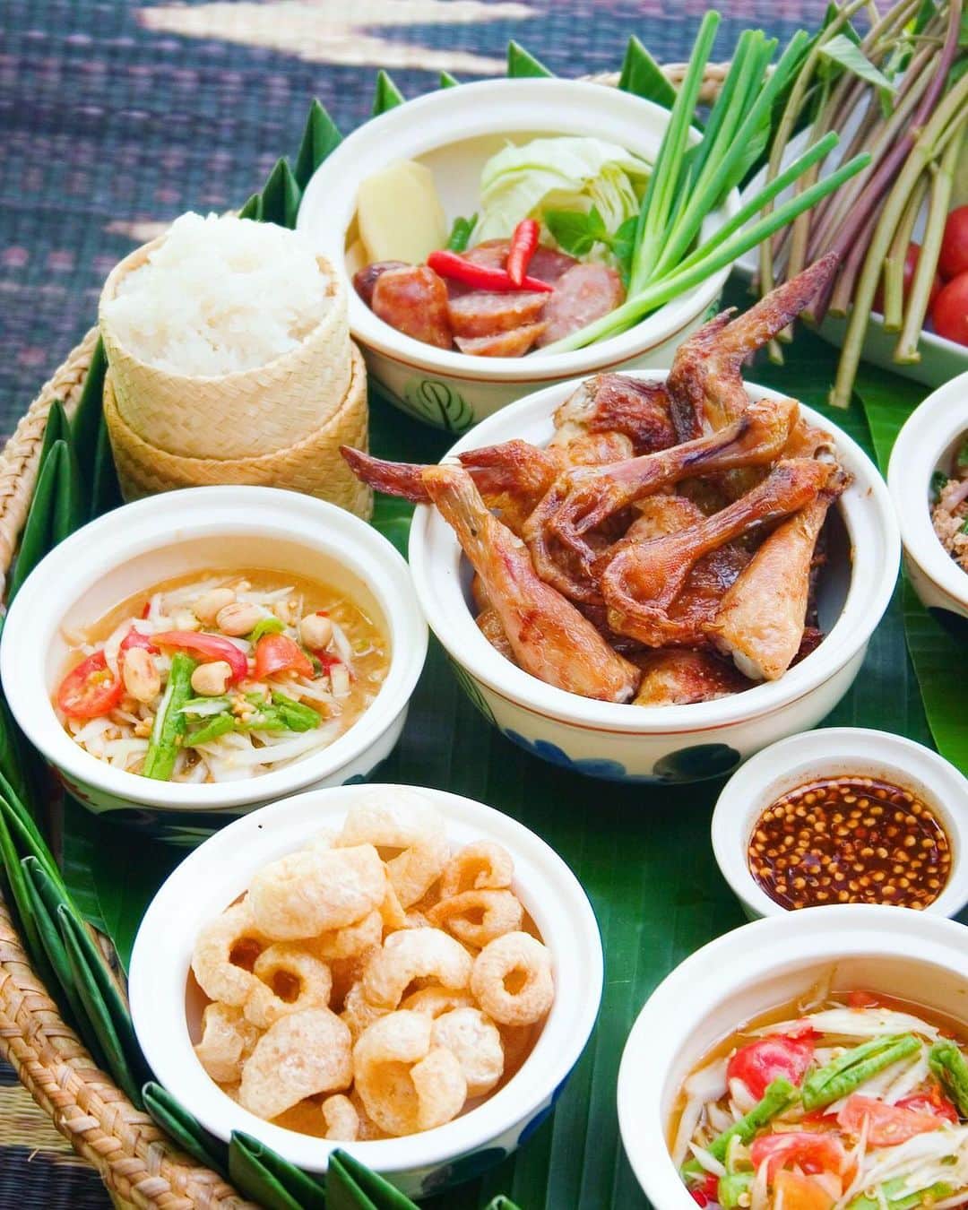タイ国政府観光庁さんのインスタグラム写真 - (タイ国政府観光庁Instagram)「・﻿ ／﻿ イサーン料理のある風景とともに﻿ おはようございます☀️﻿ ＼﻿ ﻿ 本日は、食欲がそそられる「イサーン料理」の写真をお届け📸﻿ ﻿ イサーン料理とは、タイ東北部の郷土料理のこと💁﻿ 「ソムタム（青パパイヤのサラダ）」や「ガイヤーン（鶏の炭火焼）」、「ラープ（細かく刻んだ肉類をハーブ等で味付けしたもの）」といった日本でもおなじみのタイ料理は、実はイサーン料理に区分されるんです🤫﻿ ﻿ 主食は餅米で、可愛らしいカゴに入ってサーブされます🌾﻿ 唐辛子をたっぷり使った料理が多く、餅米との相性も抜群🌶一度食べるとハマる人の多い料理です✨﻿ ﻿ 今週も体調に気をつけながら、1週間がんばりましょう😊﻿ ﻿ #今週も頑張ろう #タイ #イサーン #イサーン料理 #タイ料理 #タイ料理大好き #ソムタム #ガイヤーン #ラープ #食べるの大好き #食べるの好きな人と繋がりたい #こんなタイ知らなかった #もっと知りタイ #タイ旅行 #旅好きな人と繋がりたい #旅行好きな人と繋がりたい #海外旅行 #thailand #isan #isantrip #isanfood #thaifood #thaifoodstagram #thaifoodie #amazingthailand #thailandtravel #thailandtrip #thai #thaistagram #lovethailand」11月30日 8時38分 - amazingthailandjp