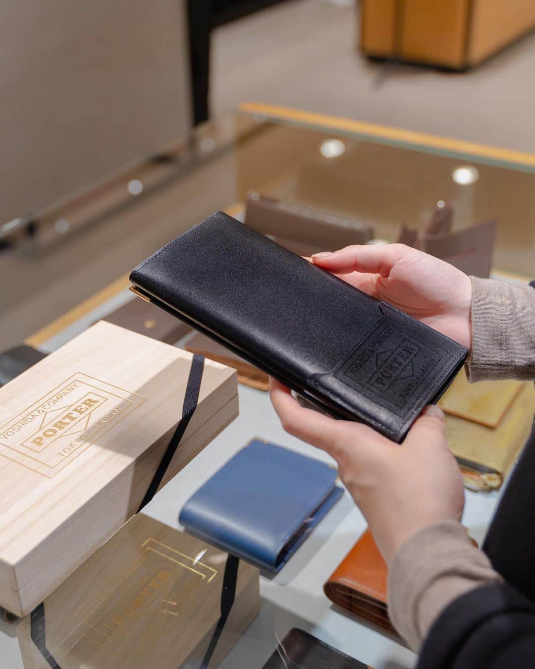 のインスタグラム：「. これからのギフトシーズンにおすすめの上品で高級感のある「PORTER CHARMANT（シャルマン）」シリーズです。  キメが細かく柔らかいフランスの最高級カーフを使用し、型からオリジナルで製作したゴールドのコーナー金具を施すことで、エレガントでオーセンティックに仕上げました。  表革はフランスの名門タンナー、デュプイ社の「シャトーブリアン」を使用しています。通常のボックスカーフに比べ、柔らかいタッチ感や独特のコシ、美しい肌目が魅力です。染料と顔料を少量ずつ加えた独自のセミアニリン仕上げで、透明感のある綺麗な色艶をお楽しみいただけます。  ゴールドのコーナー金具は、1930年代にイギリスで作られたトラベルウォレットなどに見られた装飾がモチーフです。当時はスターリングシルバーを使用し、ピンなどで丁寧に留めており、そのディテールをゴールドで取り入れてアクセントにしました。 背面には、PORTERロゴをレーザー加工で施したICカードポケットを取り付けました。 さらに、PORTERロゴをゴールドの箔押しで施したオリジナルの桐箱が付属します。  PORTER CHARMANT LONG WALLET ￥55,000＋tax W190/H105/D28mm  ぜひこの機会に店頭でお手にとってご覧ください。  #yoshidakaban #porter #luggagelabel #porteryoshida #madeinjapan #japan #porteratand #charmant #longwallet #wallet #cardcase #france #dupuy #boxcalf #leather #paulowniabox #吉田カバン #ポーター #日本製 #ポータースタンド #シャルマン #ウォレット #財布 #カードケース #革 #レザー #桐箱」