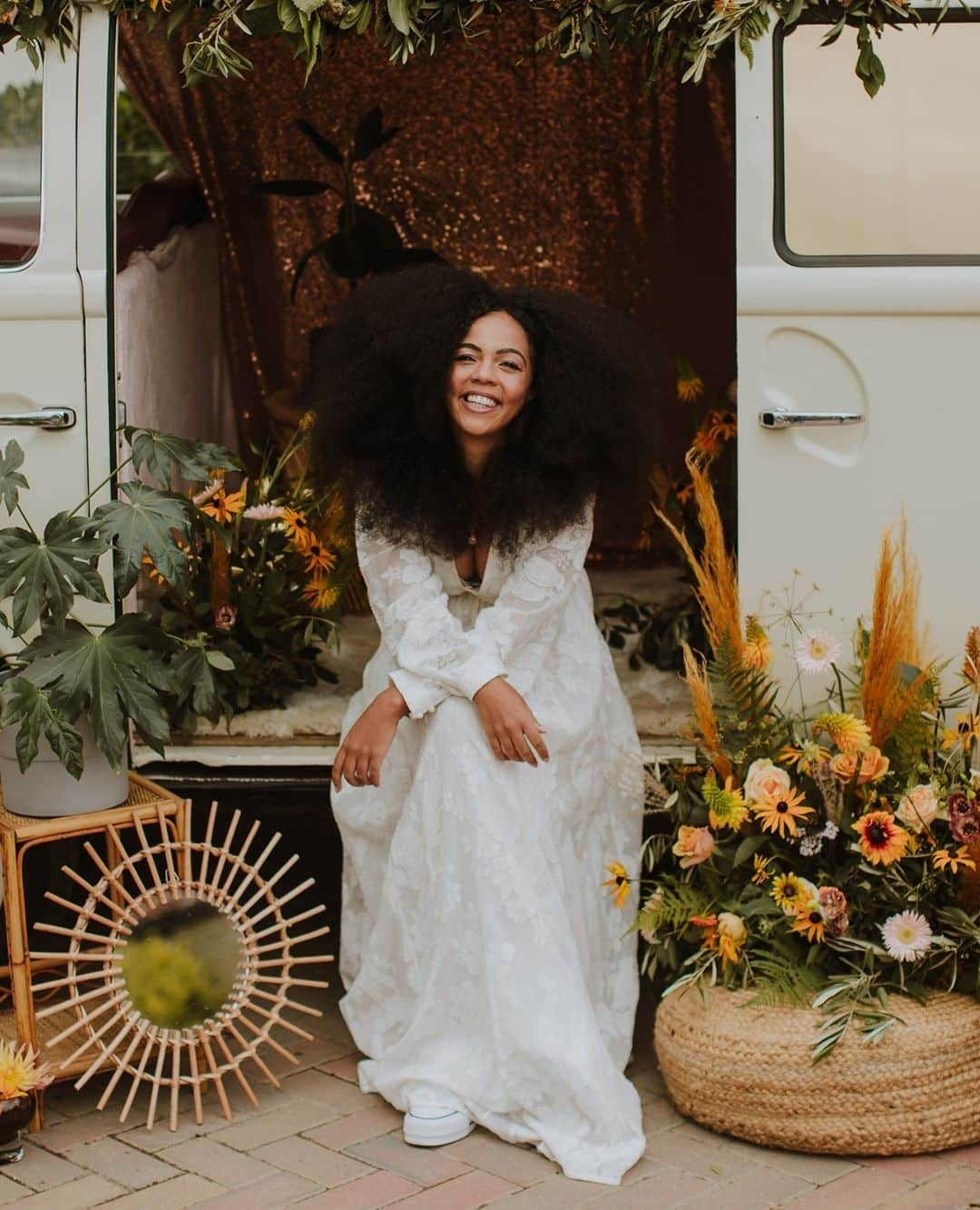 ミナのインスタグラム：「✌️😍 Absolutely thrilled to finally share this shoot featuring our Lucinda dress with all you hippie brides! Head on to @festivalbrides website to see all the 70's retro style pictures. Link in bio. 😍✌️⁠ ⁠ "Oh my my my, do we have an absolute treat for your wedding planning eyes this weekend in the form of this gorgeous 1970’s vintage bohemian styled wedding shoot which we love love LOVE. Not only is it channeling the carefree hippy vibes of a trend setting liberal decade we would have loved to witness, it also comes with a colour palette and decor style after our own hearts. Think patterned and floral textiles in mustard, blush and green, vintage lampshades your grandmother would have been proud of, flowers that look like they have been scooped up from a wildflower meadow and, the staple to any 1970’s inspired shoot, a VW campervan! It is awesome and we haven’t even mentioned the incredible stationery and cake which both champion bold and beautiful blush flowers in their designs, and compliment the overall hippy vintage floral theme so perfectly."⁠ ⁠ Photographer and Videographer - @sambennettphoto ⁠ Venue- @strattoncourtbarn ⁠ Florals- @wildsapphireflorist ⁠ Stylist - @thevintagehousethatcould ⁠ Vintage Camper Booth - @vintage_camperbooths ⁠ Dress - @indiebride.london ⁠ Cake - @cherrytreecakerie ⁠ MUA and Hair - @tonisearle_mua ⁠ Stationary - @annajaynedesigns ⁠ Jewellery - @fionalucybespoke ⁠ Hair Accessories - @aureusflos ⁠ Model- @curlyculzeane ⁠ ⁠」