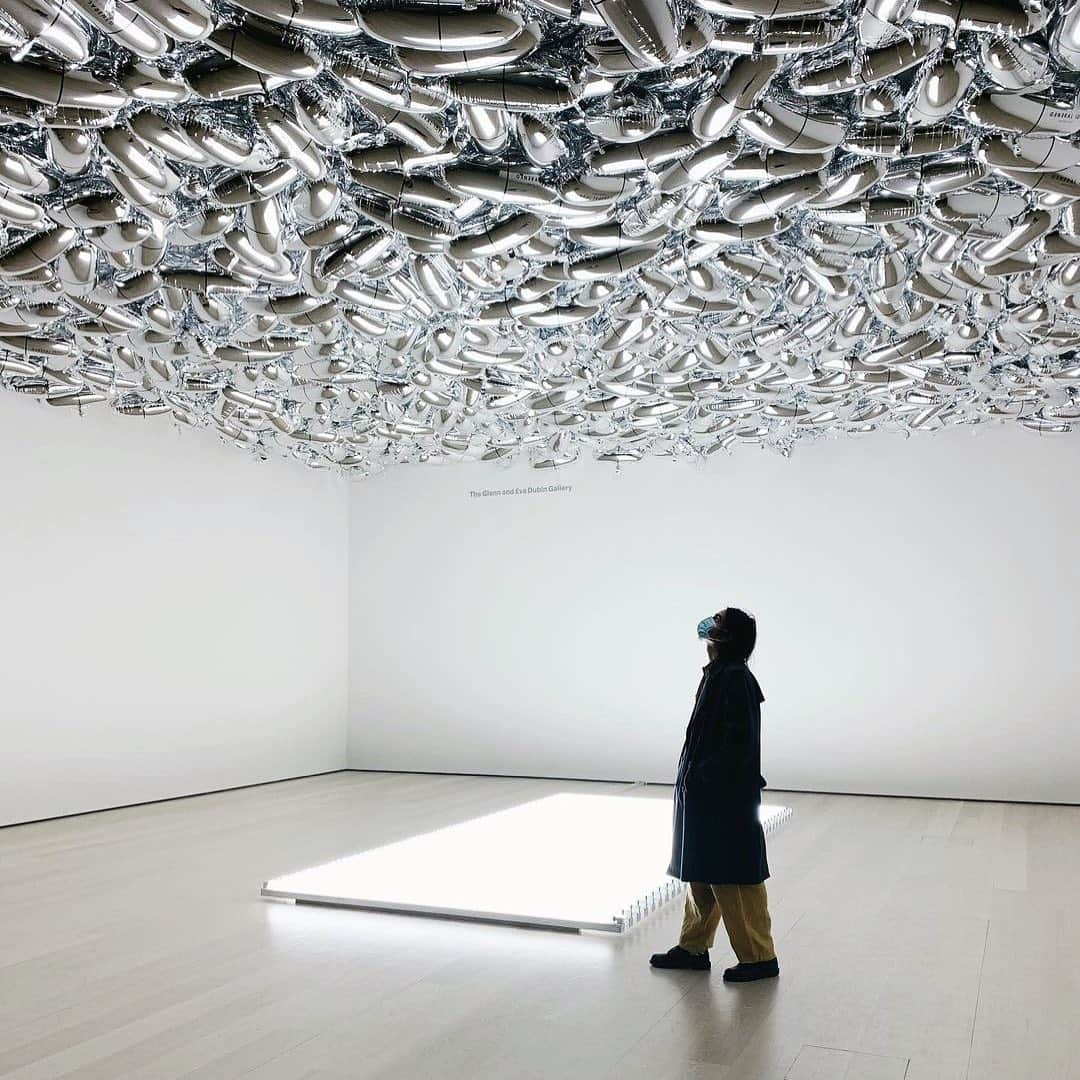 ニューヨーク近代美術館のインスタグラム：「“We were all surrounded by pills. The pill became a sculptural form we turned into our art,” artist @aa_bronson, a member of the Canadian collective @generalidea_, remarked on the inspiration for Magi© Bullet, when it was first installed, in 1992, at the height of the AIDS crisis.  On #WorldAIDSDay, we're reflecting on the powerful work, which fills our fourth-floor gallery with pill-shaped mylar balloons. As the balloons’ helium levels decrease, they fall; you are invited to take a deflated balloon home with you. The installation gradually disappears over time, evoking the lives needlessly lost to aids because of state abandonment—and prompting comparison to the current global pandemic and the harm it’s wrought on our most vulnerable communities.  Comprising Bronson along with Felix Partz and Jorge Zontal, #GeneralIdea was active from 1967 until 1994, when Partz and Zontal passed away from AIDS-related illnesses.  📸 @busca__vida」