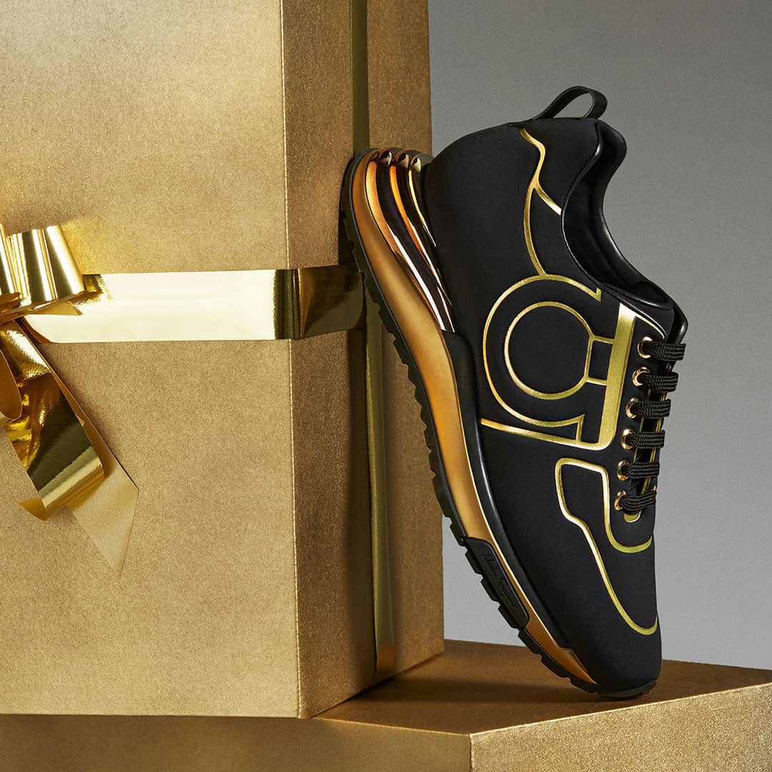 サルヴァトーレ・フェラガモのインスタグラム：「A Flicker of Light with Every Step. Step into the holiday season with a flamboyant flair, in a gold-lined Gancini sneaker, the thick sole of which mimics the iconic lines of the Rainbow heel, with rounded layers in three contrasting finishes. #FerragamoHoliday #UnwrappingJoy」
