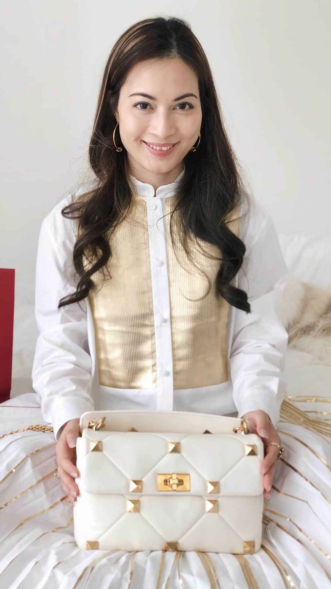 Ruby Kwanのインスタグラム：「To welcome my favourite December, I need a #ValentinoUnboxing. ❤️ The bag we all need right now is the #Valentino #RomanStud. ✨✨✨ @maisonvalentino #rougeclosetunboxing  Turning the antique-brass-finish metal twist-lock, I am open to the new Roman Stud chain bag in white lambskin nappa. Quilted construction, embellished with maxi studs. Equipped with a detachable handle and sliding chain strap, this amazing Roman Stud bag can be worn as a crossbody/shoulder bag or carried by hand.  With nearly a year of struggling with the COVID-19, everyone has a new way of normal. For me, I have a big re-think about my personal style. Buy less buy better. Quality over quantity. These are true to me as always. But I also need to add practicality. 💫 Yes, I used to be a look-good over practical person. But I changed a bit for the year.  This Roman Stud comes to me at the very best time. It’s not only chic and pretty, it is so roomy to keep all the things I need on the street.  ___________________________________ #valentinohongkong #valentinohk #ValentinoGaravani #valentinobag #valentinoromanstud #valentinolovers #valentinostyle #whiteandgold #whitebag #studbag #lambskinbag #luxurybags #luxurystyle #rubykwan #quilted #quiltedbag #whitestyle #baglove #unbox #unboxingvideo #openbox #newbag #bagoftheday #bagoftheyear」