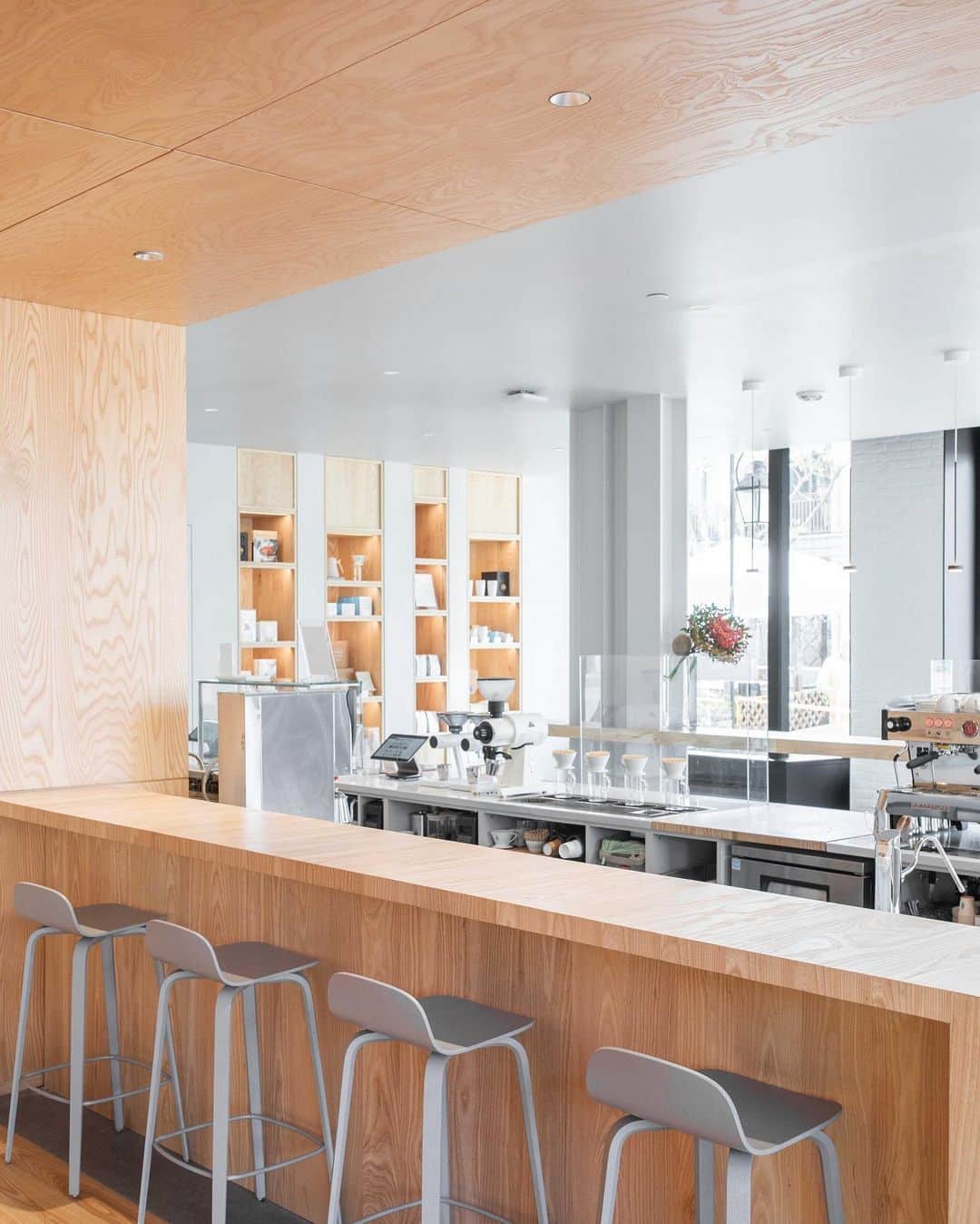 Blue Bottle Coffeeさんのインスタグラム写真 - (Blue Bottle CoffeeInstagram)「Welcome to the Blue Bottle family, B Street!⁠⠀ ⁠⠀ Our B Street cafe resides in a landmark Art Deco building that has been a social hub in San Mateo’s downtown since 1931. Its many incarnations include cigar store, soda fountain, and clandestine hall for bookmakers taking bets. We designed our cafe with such conviviality in mind, conceiving the seating area behind the coffee bar as a “room within a room,” demarcating it with tawny ash wood paneling that clads both ceiling and walls. The effect is like a modernist take on the steak house of yesteryear, where the right mix of darkness and warmth spotlight the immediate pleasures of coffee and food at hand. ⁠⠀ ⁠⠀ In the heart of the seating area is a spacious and round communal table built for Blue Bottle Founder James Freeman. Designed by @bohlincywinskijackson, the same architectural firm that designed this cafe, and built by Tomlinson Woodworks, the table, once used in Freeman's home, is now a space to gather and enjoy our rotating selection of single origins and blends, and our seasonal culinary menu.⁠⠀」12月3日 2時37分 - bluebottle