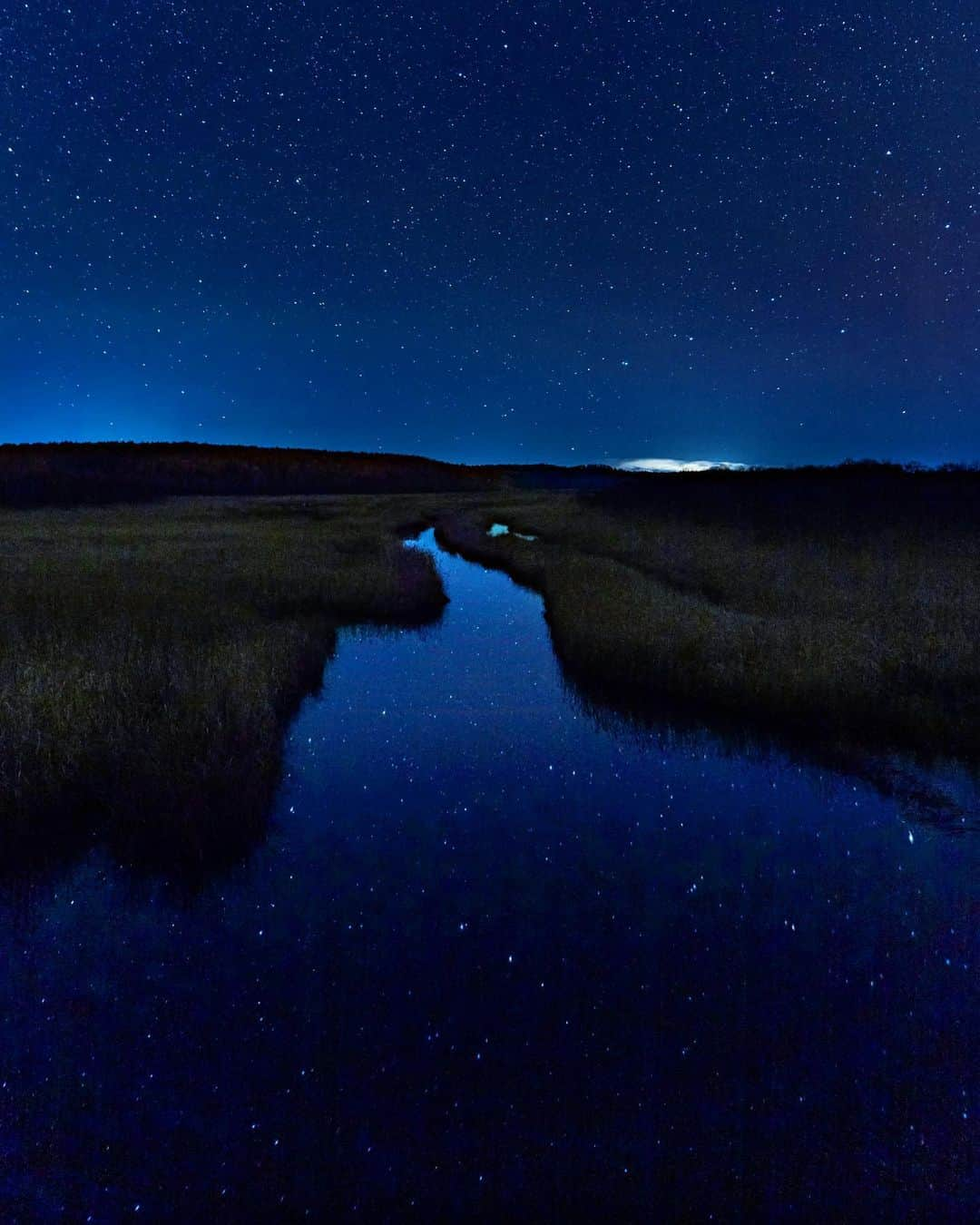 詩歩さんのインスタグラム写真 - (詩歩Instagram)「水面に反射するダブル星空🌌﻿ ﻿ 北海道くしろの #霧多布湿原 を夜通りかかると、湿原の水面に星空が！﻿ ﻿ 湿原の川は流れが少ないから、美しい星空が水面に反射するのです👏﻿ ﻿ 上にも下にも満点の星空……宇宙かな？🪐﻿ ﻿ ﻿ 琵琶瀬川にかかる寿磯橋から撮影しています📷﻿ ﻿ ﻿ ✈️﻿ ﻿ 北海道庁さんのお仕事で、北海道の東側に位置する釧路エリアを巡ってきました！ #詩歩のくしろ旅 のタグでこれから発信していきます。﻿ ﻿ 🌟﻿ ﻿ “Double” starry sky reflected in the water surface!﻿ ﻿ Passing by the #KiritappuMarsh in Hokkaido at night, you can see the starry sky on the surface of the marsh! The river in the marsh has a low flow, so the beautiful starry sky reflects in the water 👏﻿ ﻿ Is the sky full of stars above and below ...... am I in space? 🪐This photo is taken from the Kotoiso Bridge over the Biwase River.﻿ ﻿ ﻿ ﻿ 🙏旅行を検討中の方へ﻿ 政府や自治体が発表している新型コロナウイルスの最新情報を確認し、遠方の感染拡大エリアへの訪問は控えるなどご自身で判断をお願いします。この投稿は時差投稿です。﻿ ﻿ ﻿ ﻿ 📍 霧多布湿原　寿磯橋（こといそ橋）／北海道 ﻿ 📍Kiritappu Marsh Kotoiso bridge／Hokkaido Japan﻿ #shiho_hokkaido﻿ ﻿ ﻿ ﻿ ©Shiho/詩歩﻿」12月3日 9時05分 - shiho_zekkei