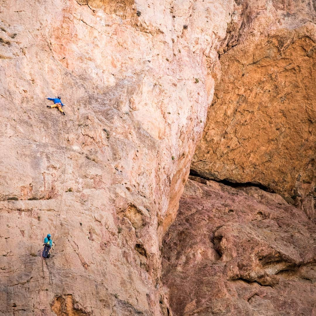 ヨルグ・バーホーベンのインスタグラム：「Taghia, Morocco, 2017 🌍 Travel memories: part 1 • I planned to visit Taghia's red limestone walls for a long time already, when @arnaudpetit_climb told me about a project he never finished bolting. When he sent me photos of a 400 meter wall overhanging for half the way, I was sold right away.  • The village of Taghia sits deep in the mountains several hours from the nearest road. A few hundred berber people lead an honest but hard life (electricity came only a few years ago), sheepherding and farming the hillsides around the canyon.  • Rock climbers have been coming here since the 90ies, when legends like Michel Piola discovered the many steep walls up to 1000 meters, and it's been a climbing mecca since. • After climbing some of the classics, @jonglassberg and I set off to finish Arnaud's route, climbing and bolting for several days until we reached the summit of the Tadrarate wall. Out of the 12 pitches, 5 are estimated between 8b and 9a, making this a unique project. Hard boulder problems, some long runouts, and endless mini crimps. Any takers? • I'm not sure when I will return, and if so, I doubt I will be strong enough to free this line, but one day someone will take over and finish what has been started even before I came: 'the Marrakech Express' • photography by @jonglassberg #lt11 @marmot_mountain_europe」