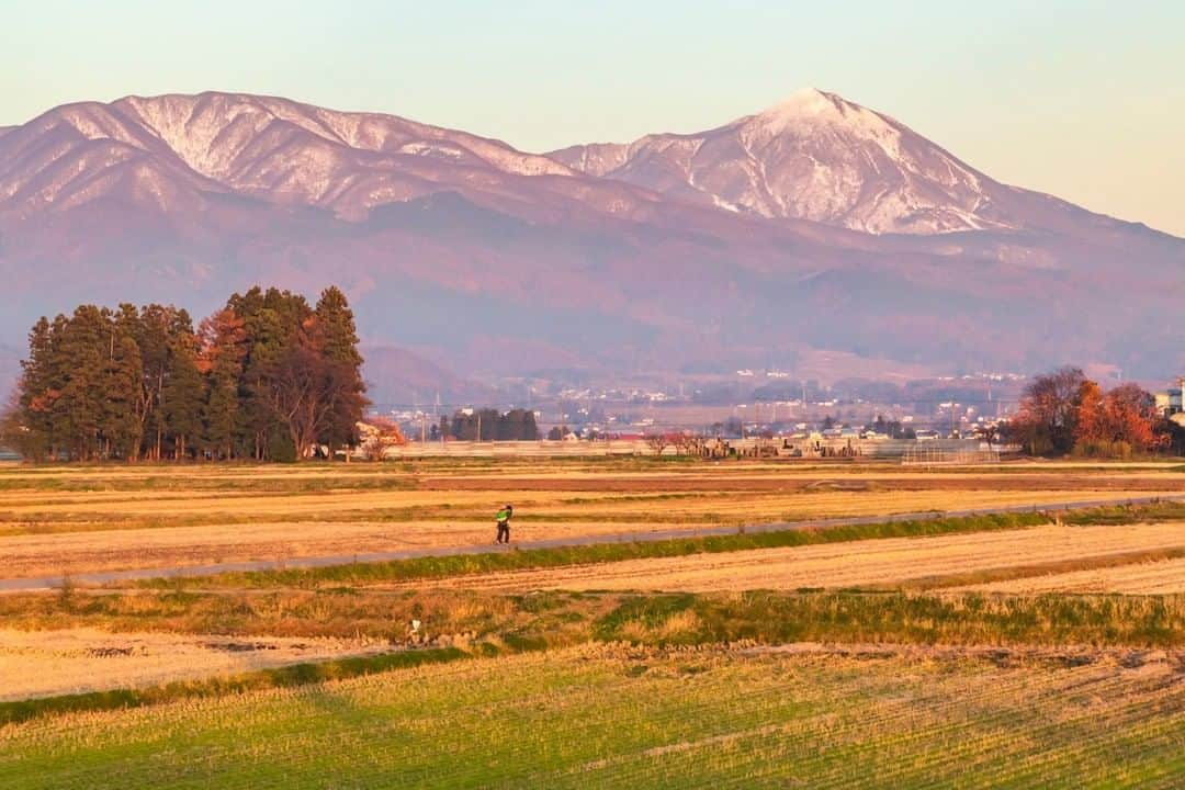 のインスタグラム：「【会津盆地の夕暮れ】  雪化粧をはじめた磐梯山と会津盆地に夕暮れが迫ります。鎮守の森と、たわわに実った会津名産の柿の木が、家路を急ぐ母子をやさしく見守ります。  #会津盆地 #磐梯山 #湯川村  #会津 #福島県 #yugawavillage #fukushima #traveljapan #futurefromfukushima #ふくしまからはじめよう #新しい生活様式からはじめよう」