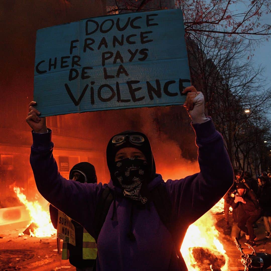 AFP通信さんのインスタグラム写真 - (AFP通信Instagram)「AFP Photo 📷 @anne.christine.poujoulat - A protester holds a sign reading "Sweet France. Dear country of violence" in front of a fire during a demonstration for 'social rights' and against the 'global security' draft law, which Article 24 would criminalise the publication of images of on-duty police officers with the intent of harming their 'physical or psychological integrity', in Paris, on December 5, 2020.」12月6日 6時45分 - afpphoto