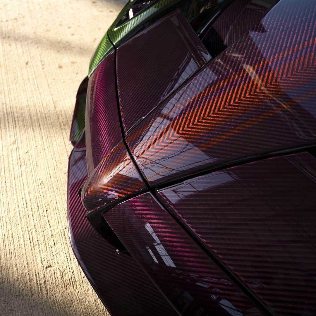 パガーニ・アウトモビリのインスタグラム：「A diamond made out of carbon fibre that wonderfully shines under sunlight.   This magnificent exemplar of Roadster BC displays three types of visible carbon fibre: the top of the car is Morgana purple, the middle is Smeraldo green, while the central stripes, the fins, the mirrors and the lower parts of the sides are Acero red. How wonderful!  #pagani #huayra #roadsterbc #ParcoInnovazione」