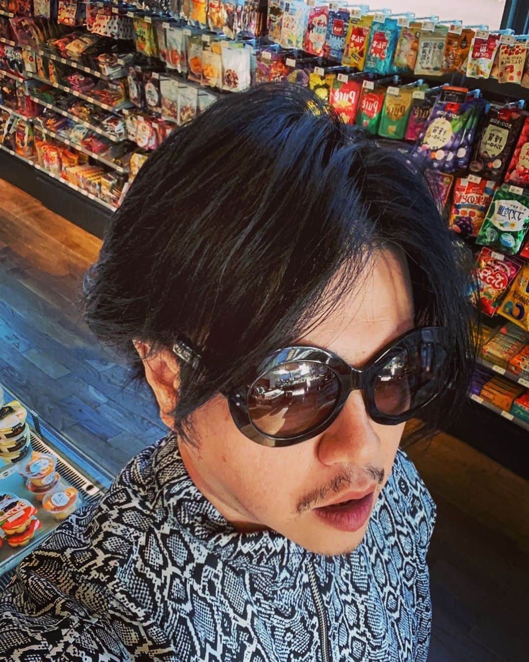 渋谷慶一郎のインスタグラム：「ずっとこもって制作してて昼ご飯にパスタとファミチキ買いに来たらジャージが派手でzoomの合成画像のようになった (ちなみに上下セットアップ) I've been working on it for a long time, and when I went to the convenience store to get pasta and famichiki for lunch, my jersey was so fancy it looked like a composite image... (It's a top and bottom setup, by the way). @noongoons  lol」