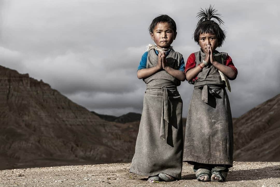 Cory Richardsのインスタグラム：「I took this picture during my first assignment for @natgeo.⁠ ⁠ The two Tibetan kids in the photo are in an area of upper Mustang called Chhoser, where the people still inhabit cave dwellings. Mustang was off limits to tourism until 1994, so it’s only fairly recently opened up. But it’s seldom visited by anybody other than its residents. We were on a scientific expedition using climbing to explore ancient burial crypts to get an idea of human migration along the Silk Road. It was a fusion of science, culture, and adventure: a golden trifecta for storytelling.⁠ ⁠ I have a deep passion for their culture, and I try to use images to promote its preservation. These two kids stepped in front of the camera and made the Namaste gesture you see in the image without being prompted or cued. And I was fortunate enough to be there with my camera to make the shot.⁠ ⁠ They remind me that my decisions have impacts that are more far-reaching than I might think. When I make a decision in my life, I want to be conscious of how I can positively or negatively impact the entire human family. Knowing that there are these fragile cultures out there, and our decisions do have impacts, is very important.」