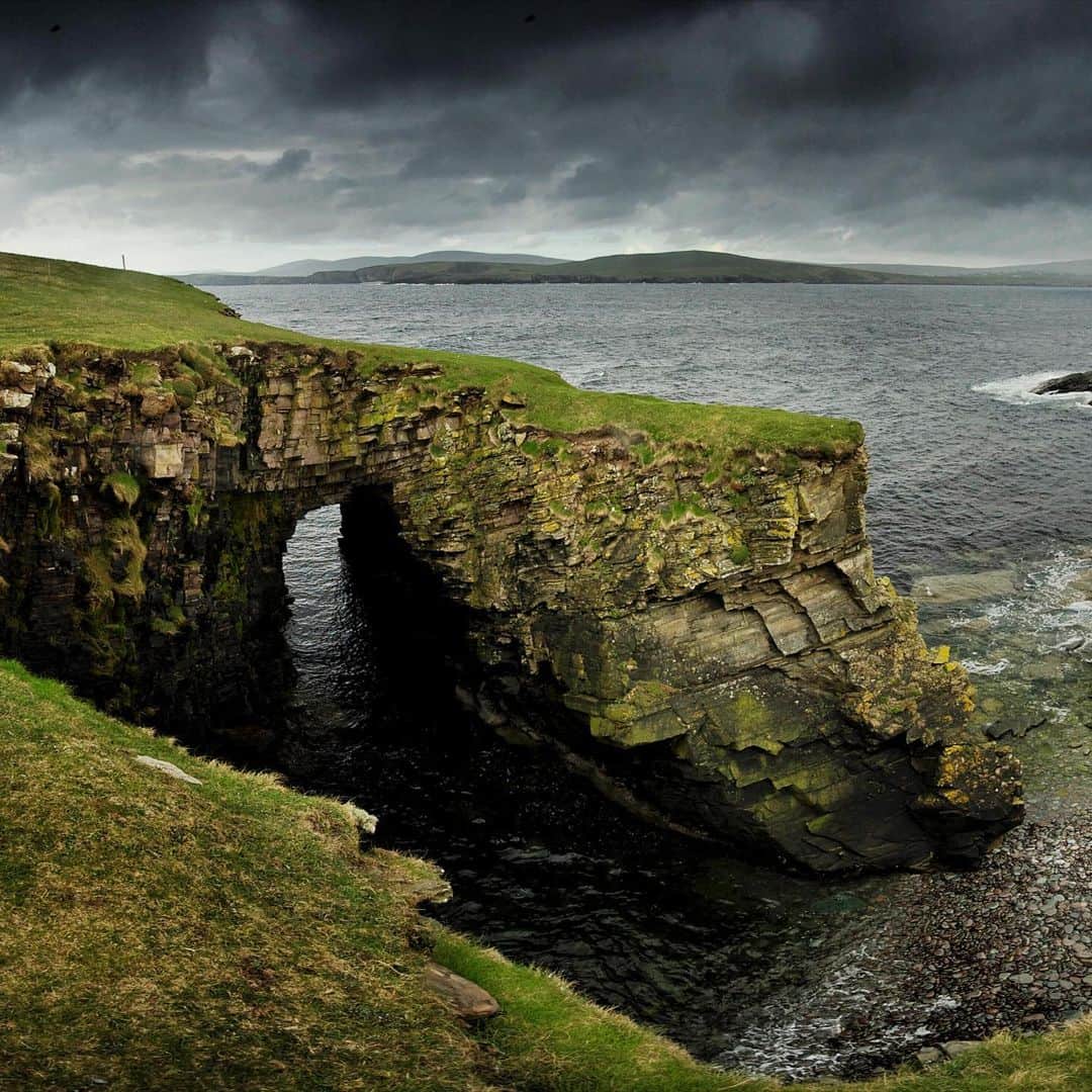 National Geographic Travelさんのインスタグラム写真 - (National Geographic TravelInstagram)「Photo by @jimrichardsonng / The rugged coastline around Mousa Broch in Shetland, shrouded under dark skies on this day, reflected the rugged life in the Iron Age. The rocky outcrops tell you where the islanders got their building material 2,000 years ago. The sandstone easily broke off into neat flagstones, perfect for building the round tower 42 feet (13 meters) high with walls 15 feet (five meters) thick at the base. Because these Iron Age people could build so easily in stone, the archaeological record in Shetland and Orkney is exceptional. Mousa is the best preserved of the more than 500 brochs that were built in the islands and northern Scotland. Anybody who was somebody wanted an impressive broch during that ambitious age.  For more Scotland, follow @JimRichardsonNG.」12月8日 4時49分 - natgeotravel
