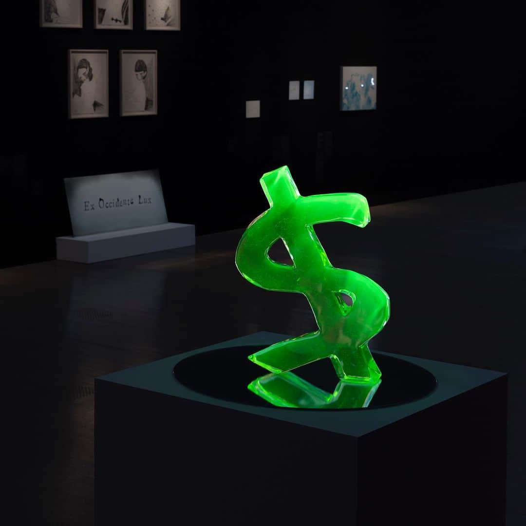 小林エリカさんのインスタグラム写真 - (小林エリカInstagram)「ドル Dollar  ウランガラス、鏡、紫外線ランプ　 Uranium glass, mirror, ultraviolet lamp　61.0×41.0×7.5 φ70cm 2017 協力：妖精の森ガラス美術館    In the 16th Century, the silver mined from Sankt Joachimsthal was minted into coins called Joachimsthalers, or thalers for short, that eventually circulated as far as the New World, as dollars—this is the origin of the word dollar. In the 18th Century, the new element uranium was discovered, and now it was uranium, not silver, that brought wealth to this village. When uranium is mixed with glass, it glows fluorescent green under ultraviolet light, and cups, accessories, and the like made from uranium glass were prized by the European aristocracy.  16世紀、聖ヨアヒムの谷で採れた銀から鋳造された銀貨ヨアヒムスターラー、略称ターラーは、後にその名が新世界アメリカへまで渡り、ダラー、ドルの語源になった。 18世紀、新元素ウランが発見されると、銀にかわりウランが町に金をもたらした。ウランはガラスに混ぜると、紫外線の光で蛍光グリーンに輝き、ウランガラス製のグラスやアクセサリーなどがヨーロッパの貴族たちにもてはやされた。  “Image Narratives: Literature in Japanese Contemporary Art”, 2019, The National Art Center, Tokyo, Installation View, Photo: Shu Nakagawa 「話しているのは誰　現代美術に潜む文学」展　国立新美術館　2019  Courtesy of Yutaka Kikutake Gallery Thanks to 軽井沢ニューアートミュージアム、GALLERY360°、松藤孝一、 三浦和  #uranglass #dollar #erikakobayashi」12月8日 16時58分 - erikakobayashiek