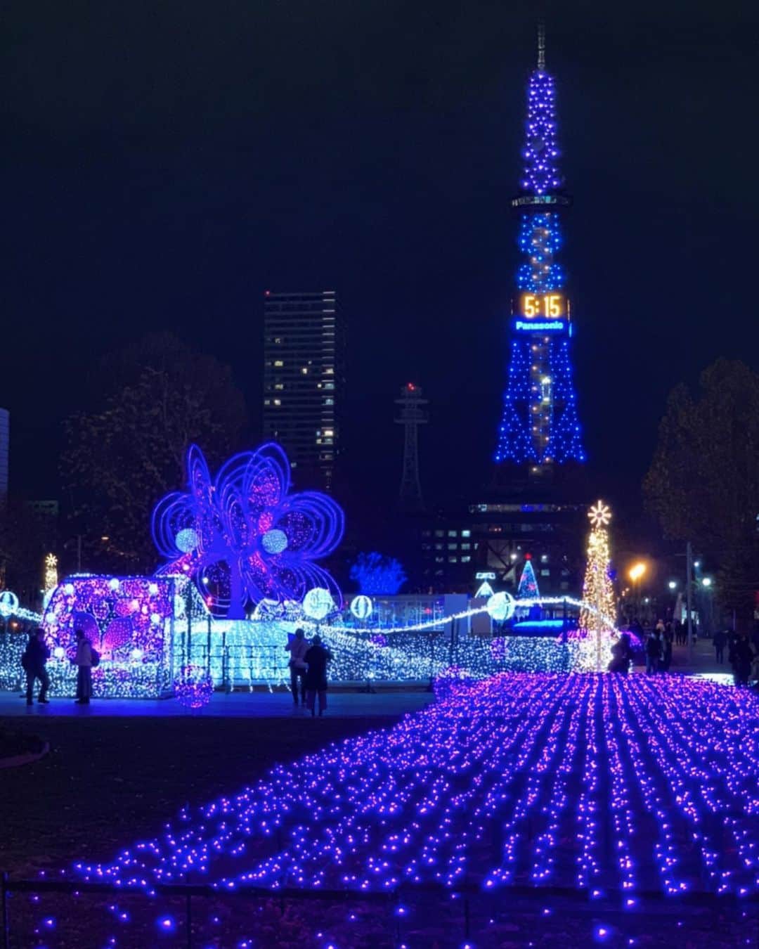Sayaka.Mさんのインスタグラム写真 - (Sayaka.MInstagram)「. #Sapporoillumination 今回ご紹介はイルミネーションの様子 . 今年は残念ながらいつもの様な賑わいにはなりませんでしたが、大通3丁目会場花咲く「ブルーミング・ファウンテン」を見てきました☺️🙌 . 会場中央の噴水に、ライラックの花をモチーフにした大型のオブジェと、花と季節の移ろいを、光と音の動きのある演出で表現されてます。パープルのグランドイルミネーションも✨ また、通路の路面へライラックの花、40回記念ロゴ、サッポロスマイルを照射する演出が また、大通4丁目会場ではダイヤモンドをモチーフにした光の宮殿「ジュエリー・パレス」、中央の噴水を使った光の噴水が設置されているほか、ダイヤモンドオブジェやブルーグリーンを基調としたグランドイルミネーションがあります。通路の路面へダイヤモンド等を照射する演出も。 また、40回目の開催を記念して、「さっぽろホワイトイルミネーション」の歴史パネルを展示するほか、芝生へ40回記念ロゴやサッポロスマイルを照射する演出も😌💕 . 今、札幌市ではサッポロスマイルプロジェクトというキャンペーンをやっています キャンペーンには3つのミッションがあり、3つのテーマに沿った写真を大募集してるんです。 ①札幌ならではの四季の魅力や、グルメ、イベント、夜景、穴場スポットの発信 ②新北海道スタイルの取り組みにより新たに見つけた楽しみや魅力の発信 ③マスクに自由にサッポロスマイルのロゴを描いて発信 . @sapporo_smile_official をフォローして、それぞれのミッションに指定のハッシュタグがあるので、ハッシュタグを選んで投稿するだけ👍✨ 概要は @sapporo_smile_official にて 各期コンテストで選ばれた方には素敵な賞品プレゼントが！ . 今回の私の投稿はイベントなので #sapporosmileproject をつけて参加💝 . . #さっぽろホワイトイルミネーション #イルミネーション #札幌観光 #札幌インスタ映え #sapporo #北海道観光 #札幌市 #札幌ママ #札幌 #北海道ママ #夜景 #夜景撮影 #札幌ママ子連れ #札幌 #札幌旅行 #札幌テレビ塔 #sapporotrip #hokkaido #hokkaidotrip #hokkaidosgram #札幌観光大使」12月8日 21時29分 - insta.sayaka