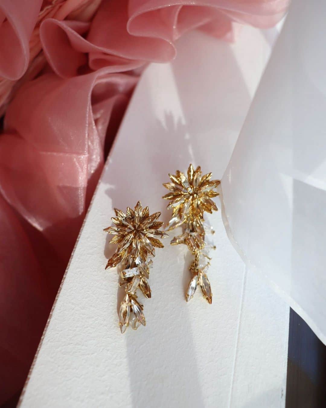 平木愛美のインスタグラム：「. swarovski  pierce （earring） 【éclat】  光の角度によって変わる煌めき。  キラキラと輝く中に、 花から溢れる愛をイメージ。  エッジが効いたシルエットの中にどこかある、花の柔らかさ。  耳元で揺れるéclatに視線を集めます。  スワロフスキーの重なりによって、品があり、上質なアクセサリー。  職人の手によって丁寧に制作致します。  オールシーズン、そして大切に長く使っていただけるようなアクセサリーとなりました。  いよいよ、明日！！！受注開始…！ 発売日⚪️12月10日（木）18:00〜17日（木）18:00 期間限定受注💠💎  #lilasmillesime #colaboracion #accessory」