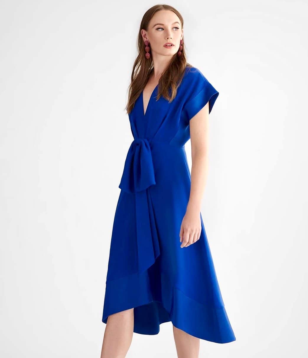 サッチン+バビのインスタグラム：「Laura in full effect. The silhouette is a flattering fit-and-flare style, and interest is brought with a high-low hemline. The collapsed bow that sits at the high waist is both sophisticated and sweet, allowing for this dress to be dressed up for the evening, or played down for the day.#chic, #blue, #sachinandbabi, #daydress」