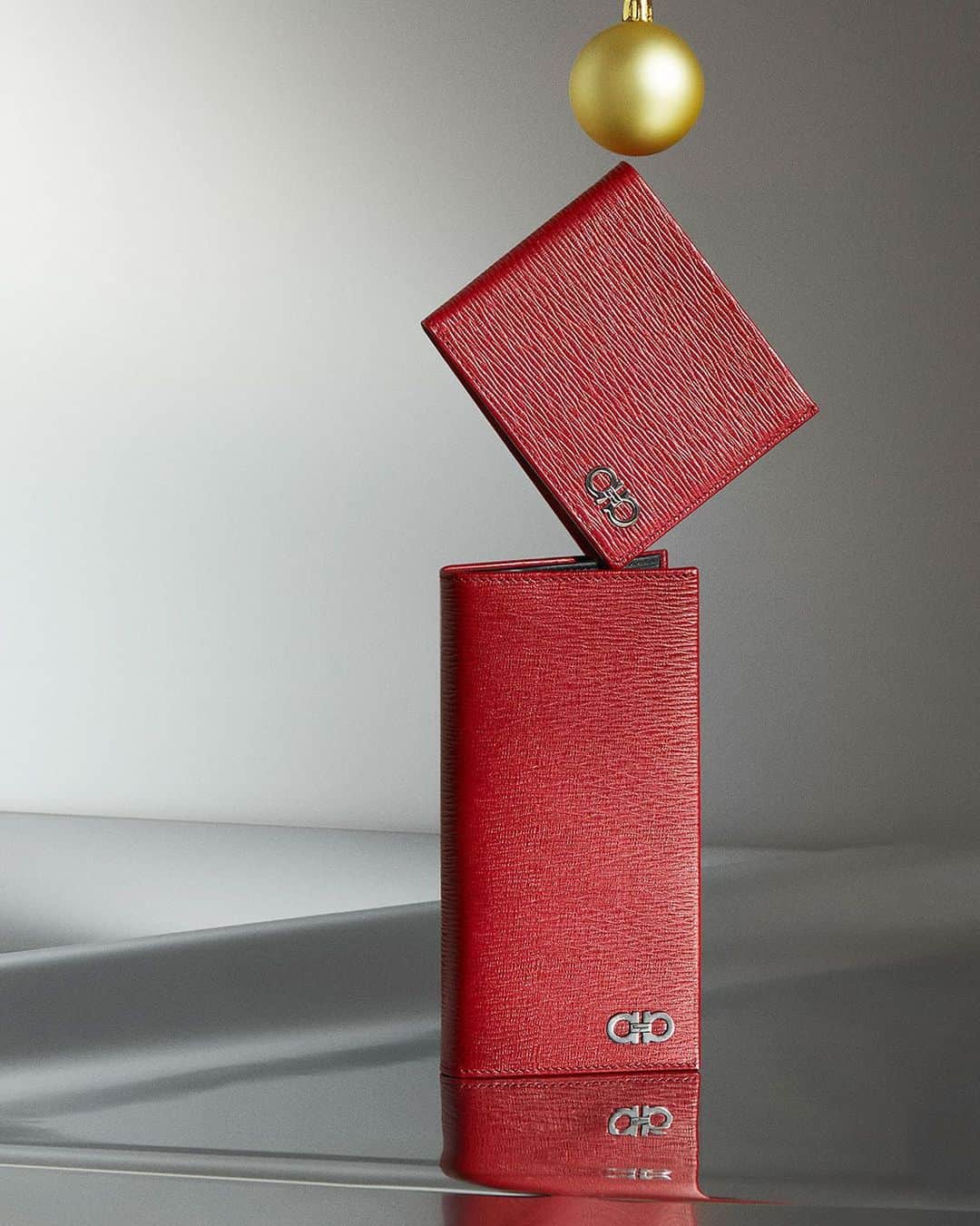 サルヴァトーレ・フェラガモのインスタグラム：「Constant Companion. Add a touch of festive cheer with a selection of red wallets crafted with a finely grained texture with the emblematic gold double #gancini clasp. #FerragamoHoliday #UnwrappingJoy」