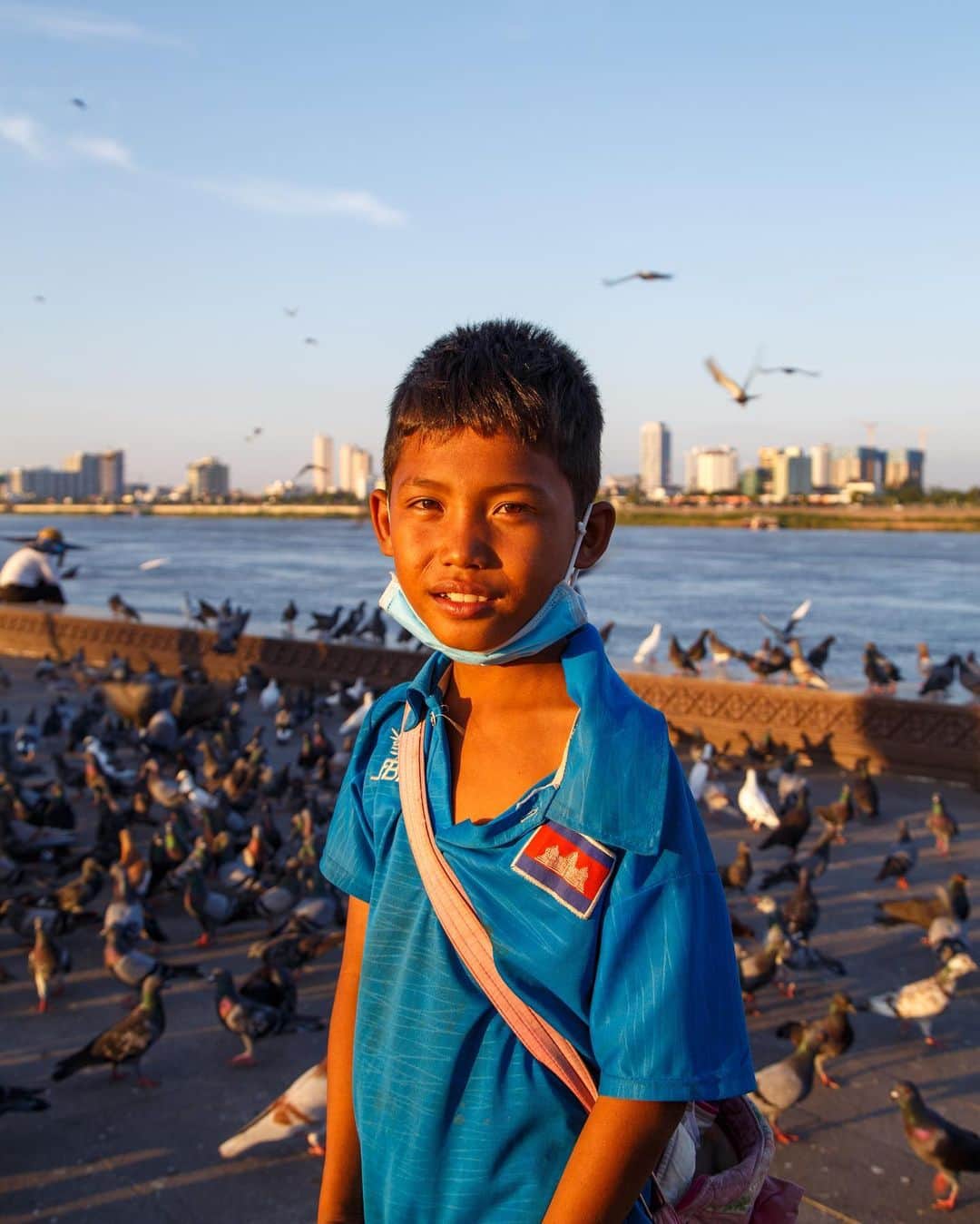 Shunsuke Miyatakeのインスタグラム：「“Today, I was shouted by a man He said to me “Don't chase me mother fucker!”  I just wanted him to feed pigeons, though”  A boy selling corn kernels at riverside, Phnom Penh, Cambodia」