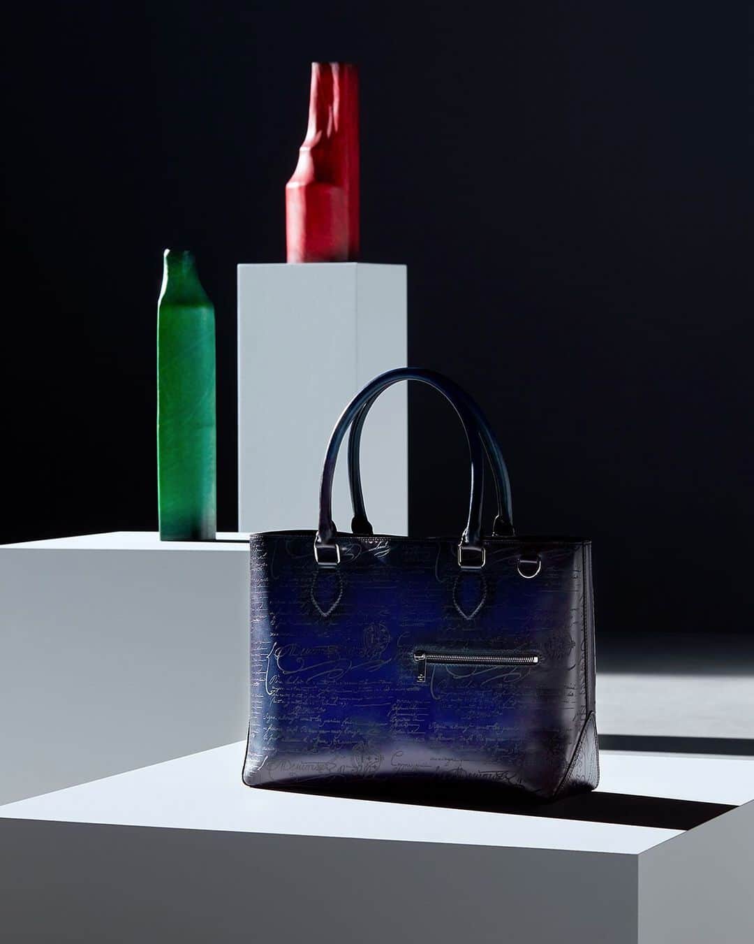 ベルルッティのインスタグラム：「- THE #BERLUTI VIBRANT HOLIDAYS BY @kris_van_assche -    This year, Berluti celebrates the end-of-year holidays with the new Home & Office Objects Collection and a selection of emblematics including the new SIGNATURE canvas collection with a colourful patina twist.   For the new Home & Office Objects Collection, Berluti has teamed up with a select group of highly respected European makers, including Werkstätte Carl Auböck, Bottega Ghianda, San Lorenzo Silversmiths and Simon Hasan, commissioning Berluti editions of iconic historic designs by Gae Aulenti, Afra and Tobia Scarpa, Carl Auböck II and III and new work by Simon Hasan, dating from every decade between the 1950’s and 2000’s.   Both functional and statement-worthy, the selection of emblematics highlights the Un Jour Gulliver, the Toujours tote bag, and the new SIGNATURE canvas collection which includes the Séjour card holder, the Explorer backpack and the Nino clutch to name a few.   For the occasion, the Venezia leather takes on a bold, joyful twist with an array of new patinas. Originally created last year especially to restore the upholstery of Pierre Jeanneret’s furniture pieces- and inspired by the rich colours found in the architecture, landscape and foliage of the north Indian city of Chandigarh -, these vibrant new colours include Utopia blue, Acqua blue, Nespola orange, Sunset purple, Rose Garden pink, Simal red and Grass green. Hand-applied to the Venezia leather and Venezia leather details of the SIGNATURE canvas accessories, they enhance every piece with a unique depth of colour.   Available In-Store and on the E-Shop.   Our Stores in France are now open and our teams will be delighted to welcome you.」