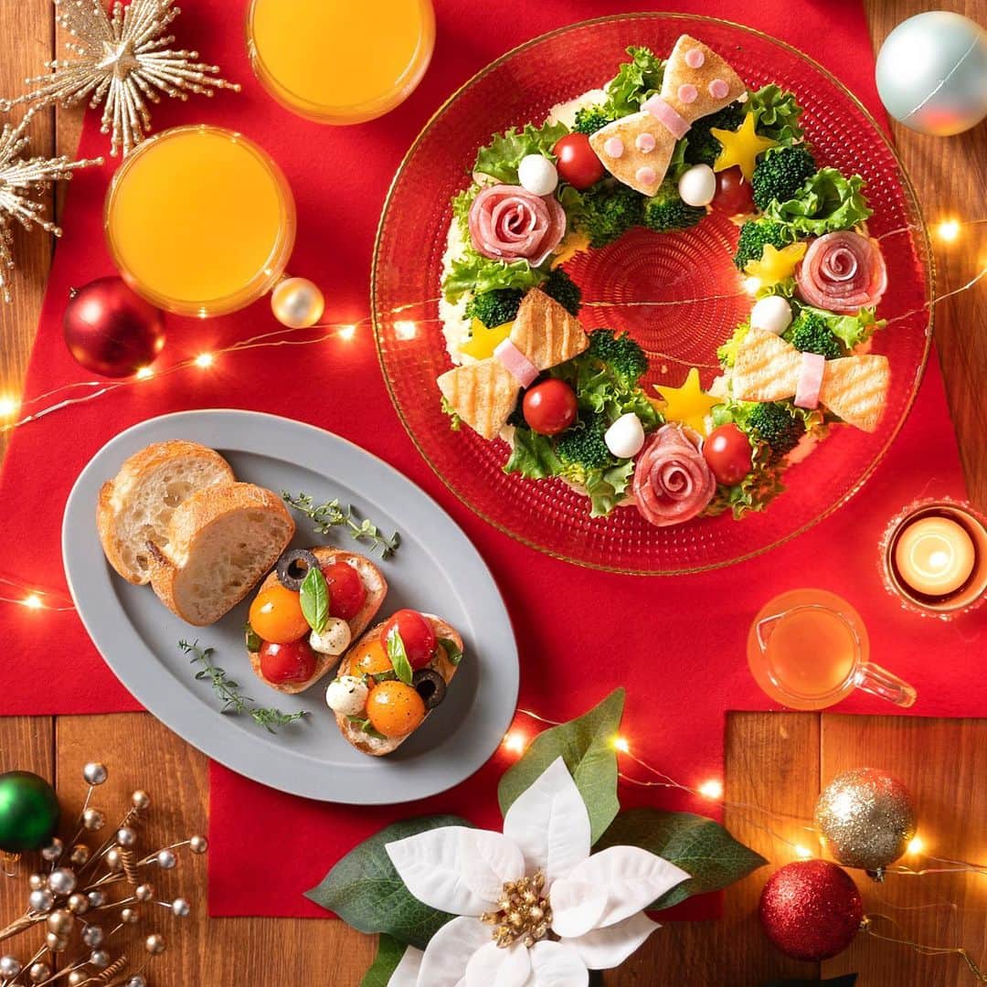 Pasco/敷島製パン株式会社のインスタグラム：「パンで楽しもう🍞#おうちクリスマス 🎉～オードブル編～ 　 クリスマスまであと14日🎄クリスマスのことを考えるだけでワクワクしちゃいますね😆 　 今年はつくる時間も楽しく！おいしい#おうちクリスマス で盛り上がりましょう🏠 当日を思いきり楽しむためには計画も大切💕オードブルは#クリスマスのリースサラダ と#トマトとモッツァレラのカプレーゼのせ にしようかな🤔 　 リースの形をしたサラダにのっているのは… #超熟サンドイッチ用 で出来た食べられるリボン!? パンを型抜きでくり抜いたら、思い思いに飾ってくださいね🎀 　 また#窯焼きパスコ国産小麦のバゲットスライス なら、あらかじめスライスされているからカラフルなカプレーゼをのせるだけで簡単おつまみに♪ パーティーメニューは、見た目ももちろん大事だけど、手軽さも欠かせないですよね☝ 　 みんなと一緒につくると、準備の時間も楽しくてあっという間☺️ いつもよりもーっとおいしくなりそうですね！ メインディッシュはなににしようかな？#パーティーの準備 はまだまだ続きます！お楽しみに✨ 　 商品について詳しくはプロフィール(@pasco.jp)のURLから🎅  #Pasco #パスコ #クリスマス  #クリスマスの準備 #パンレシピ #パンアレンジ #パーティー料理 #おうちクリスマス #超熟 #窯焼きパスコ #国産小麦のバゲット」