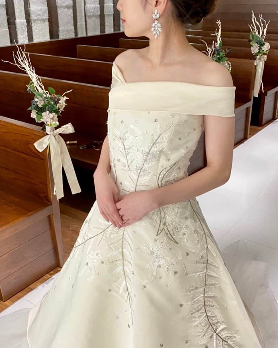 のインスタグラム：「Wedding Dress   JUNO × リストランテKubotsu 　　　　　　 　壁面に埋め込まれたクリスタルのオブジェが 　眩い輝きを放つ荘厳なチャペルに合わせて 　　 　@kenneth_pool のウェディングドレスがおすすめ 　 　アシンメトリーのネックラインが 　デコルテをより美しく、 　胸元からAラインに広がるインド刺繍は 　より華やかな印象にしてくれる 　唯一無二の特別な一着です🕊 　　　　　　　　 #junowedding  #junodress #kennethpool  #wedding #weddingdress #ウェディング #ウェディングドレス ＃ケネスプール #ドレス試着 #結婚式 #2020冬婚 #2021春婚 #2021夏婚 #2021秋婚 #プレ花嫁 #九州プレ花嫁 #福岡プレ花嫁 #少人数ウェディング #家族婚 #リストランテKubotsu #ひらまつウェディング」