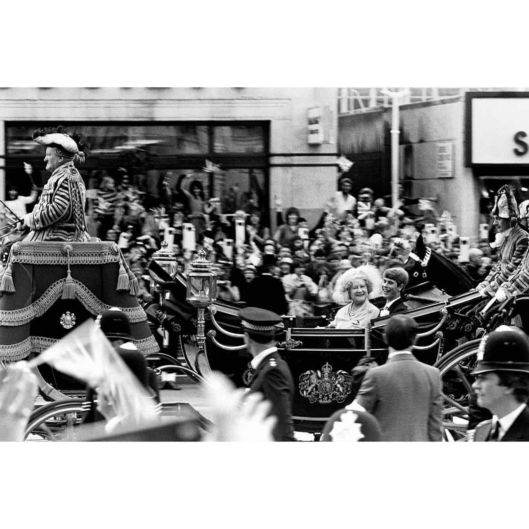 マリオ・テスティーノのインスタグラム：「I was living in Covent Garden when Prince Charles and Princess Diana got married, back in 1981. The streets were full of celebration. Everyone wanted to see the procession of carriages and cars taking the Royal Family from Buckingham Palace to St. Paul’s Cathedral, where the ceremony took place. People had been waiting for hours, with flags, signs and incredible enthusiasm, and I had to use all my powers of persuasion to get some space at the top of a phone box, from where I shot this image. Surprisingly, it looks like The Queen Mother was looking my way at the exact moment of the shot. My very first encounter with royal photography. _ Vivía en Covent Garden cuando el Príncipe Carlos y la Princesa Diana se casaron, allá por 1981. Las calles estaban llenas de celebración. Todos querían ver la procesión de carruajes y coches que llevaban a la Familia Real desde el Palacio de Buckingham hasta la Catedral de St. Paul, donde se iba a realizar la ceremonia. La gente había estado esperando durante horas, con banderas, carteles y un entusiasmo increíble, y tuve que usar todo mi poder de convencimiento para que me dejaran un espacio en el techo de una cabina telefónica, desde donde tomé esta imagen. Sorprendentemente, parece que la Reina Madre me estaba mirando en el momento exacto de la foto. Mi primer encuentro con la fotografía Real.  #BritishRoyalFamily #TheQueenMother #TestinoArchive」