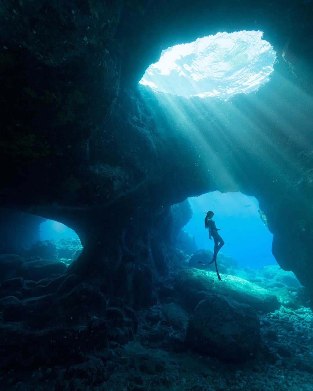 Travis Burkeのインスタグラム：「Exploring the incredible underwater world of Hawaii on a single breath.   I have to do a lot of training for these shoots, especially because I didn’t grow up comfortable in water. Being down there with my camera, holding my breath, swimming around trying to find the perfect composition and exposure, while also watching out for sea urchins, and knowing my limits on when I’ll have to start going back to the surface for air is a lot to focus on.  It’s a challenging but super rewarding process. I have a huge respect for people who have mastered this, like @aliciaunderwater, pictured here.  The next slide is a behind the scenes shot of me photographing Alicia captured by her husband @_jimward_.   The third slide was a few seconds later when I turned the camera around to show a behind the scenes of the behind the scenes 😂.  Good times during a @matadornetwork shoot for GMC.  #freediving #hawaii #bts」