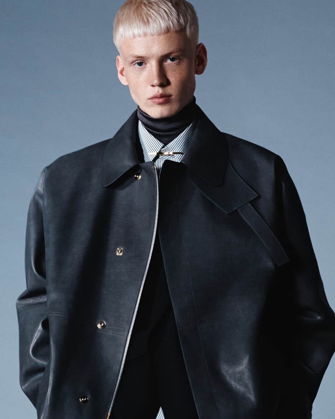 のインスタグラム：「WINTER LAYERING⁠ FESTIVE CAMPAIGN⁠ #dunhillAW20⁠ ⁠ Taken from our festive campaign for 2020, Stas wears the leather short car coat in grey-blue calfskin, with a striped cotton satin shirt, gold collar bar and knitted high neck base layer. Available now in our Instagram shop in time for the festive gift-giving season. ⁠ ⁠ Creative Director: #MarkWeston⁠ Photography: @carlijnjacobs @artandcommerce⁠ Model: @_zzztan @nextmodels⁠ ⁠ DUNHILL.COM⁠ ⁠」