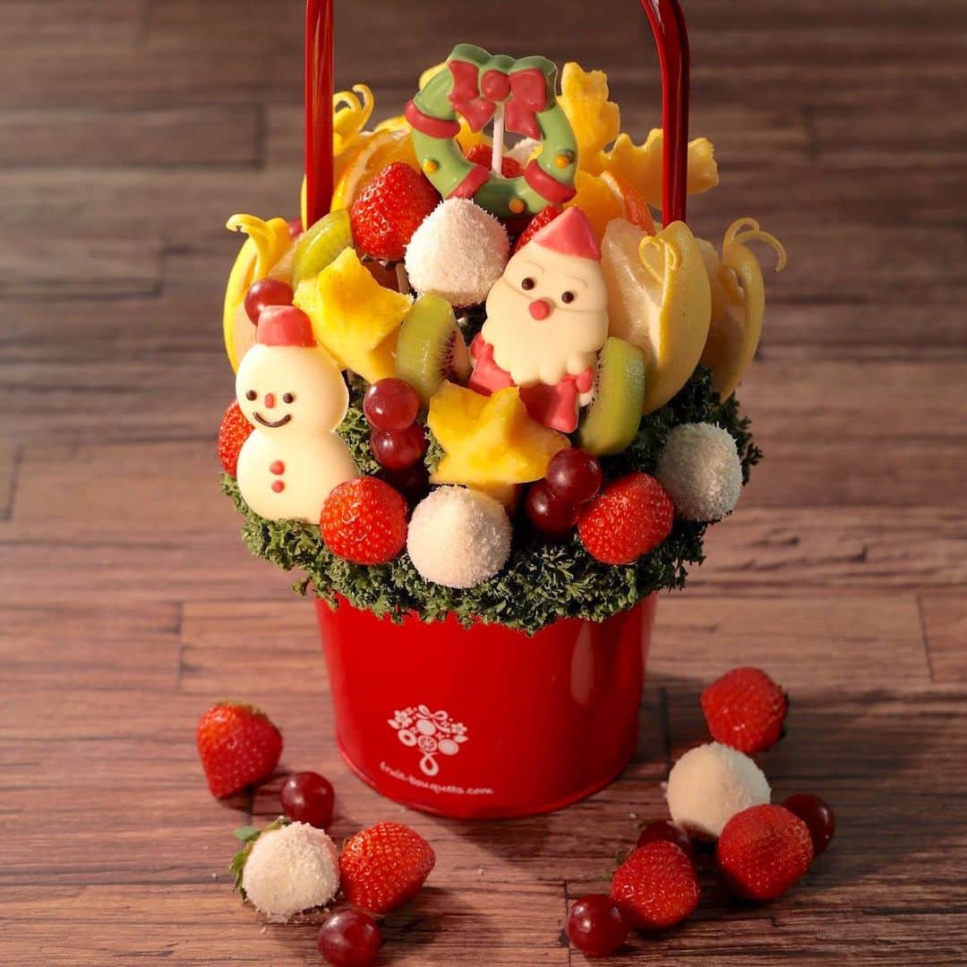 Fruit-bouquets.comのインスタグラム：「【クリスマス新作フルーツブーケ】 今年のクリスマスに新発売となる クリスマスモチーフをいっぱい詰め込んだSNS映え抜群のフルーツブーケ💐 . 今年のクリスマスはフルーツブーケで、 おうちで過ごす特別な時間を楽しんでみませんか？  甘酸っぱいおいしさが広がる国産イチゴをはじめ、 パイナップル、キウイフルーツ、ブドウ、グレープフルーツをアレンジメントします✨ . イチゴはそのままのものと、ホワイトチョコにココナッツフレークをトッピングしたものとをアレンジメントし、味わいにもバリエーションを加えています🍓 . 裏面にはトナカイの形のパイナップルがあり、360度かわいくて楽しめるデザインに仕上げました💖 . #フルーツブーケ #プレジール #フルーツ #果物 #果物大好き #フルーツ大好き #スイーツ #ギフト  #プレゼント #贈り物 #記念日  #フルーツパフェ #フルーツギフト #フルーツケーキ  #インスタ映え #インスタ映えスイーツ #インスタ映えケーキ  #花束 #フォトジェニック #パーティー  #サプライズ #サプライズプレゼント  #いちご  #クリスマス #クリスマスケーキ #クリスマススイーツ  #クリスマスプレゼント #クリスマスパーティー  #クリスマスギフト #クリスマスイブ」