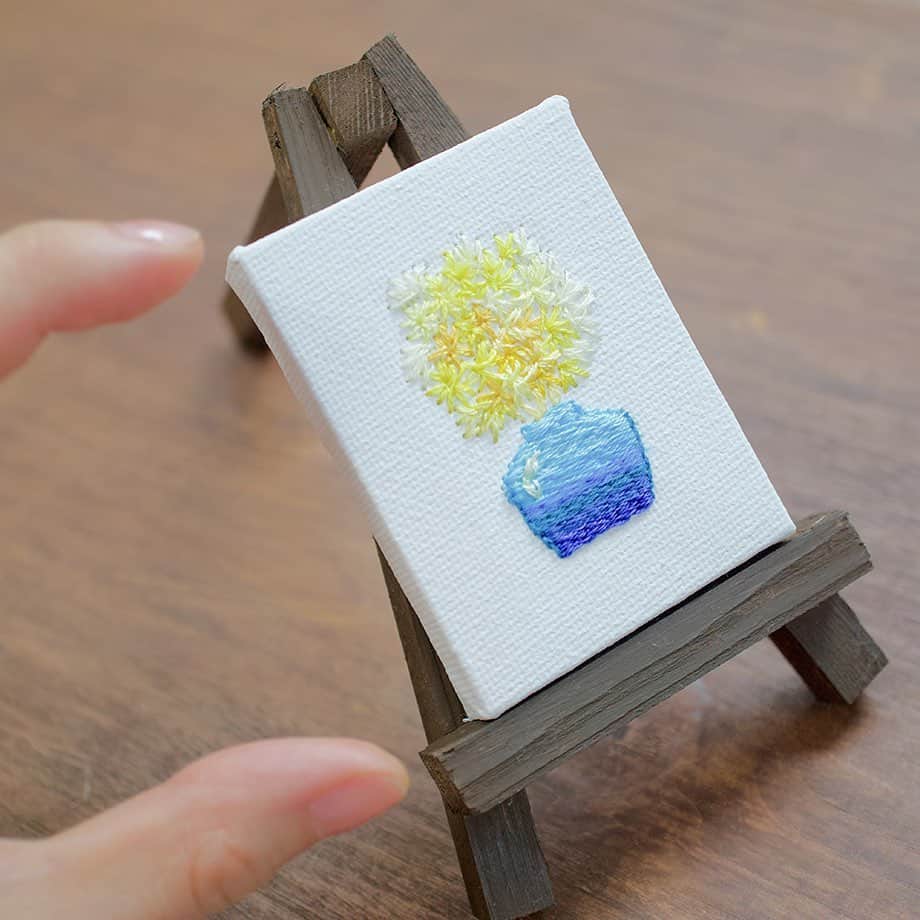 手紙社のインスタグラム：「【ミニチュアサイズのキャンバスに鮮やかな刺繍がほどこされています】﻿ 刺繍アーティスト「okada mariko」さんの作品を目にすると、それ自体は小さいけれど、その向こうに深くて広い世界の存在を感じます。布博で登場する『ミニキャンバス＆イーゼルセット』は、5cmのほどの小さなキャンバスに鮮やかな刺繍が細かく描かれています。壁にかけたり、棚や机の上に置いたりして飾ってみてくださいね。﻿ ﻿ ーーーーー﻿ ﻿ ▼okada mariko（@okadamariko_paintingstitch） ﻿ オンラインミーティング﻿ →12/17（木）18:00〜﻿ ﻿ ショップ販売期間﻿ →12/17（木）19:00〜12/24（木）19:00﻿ ﻿ ーーーーー﻿ ﻿ ＜新しいオンラインフェスティバル・布博　開催概要＞﻿ 会期：2020年12月14日（月）〜26日（土）﻿ チケット：一般 1,000円／手紙社の部員 900円﻿ 会場：「新しいオンラインフェスティバル・布博」公式サイト﻿ ▶︎詳細は「@textilefabrics」プロフィールのURLから！﻿ ﻿ ▶︎布博で販売されるアイテムを事前にチェックできる“プレビュー”開催中！　公式サイト「出展者一覧」の﻿ 「ショップを見る」ボタンからアクセス！﻿ ﻿ ーーーーー﻿ ﻿ ◎「新しいオンラインフェスティバル・布博」は3本立て！﻿ ﻿ 1）オンラインミーティング（番組）﻿ ▶︎12/14（月）〜19（土）毎日開催！﻿ 出展者による作品紹介やアトリエツアーなどの番組を生配信！﻿ 作り手との会話をお楽しみいただけます。﻿ ﻿ 2）オンラインショッピング﻿ ▶︎12/14（月）〜毎日異なる出展者が販売を開始します！﻿ 出展者による新作や、ここでしか買えない限定作品、もちろん、定番商品も購入することができます！﻿ ※それぞれの販売期間は公式サイトからご確認ください﻿ ﻿ 3）スペシャル音楽ライブ番組﻿ 12/20（日）は7時間を超える生放送をお届け！﻿ 豪華アーティスト4組による音楽ライブや、プロのスタイリストが布博アイテムのスタイリングを紹介する「ライブスタイリング」を生配信します！﻿ ﻿ #手紙社#手紙舎#布博#オンラインイベント#新しいオンラインフェスティバル#新しいオンラインフェスティバル布博#ブローチ博#布雑貨#手芸#テキスタイル#刺繍#ブローチ博#ハンドメイド#編み物#手織り#キャンバス#okadamariko#tegamisha#nunohaku#textile#textiledesign#fabric#handmade#handcraft#accessory#embroidery#布博まであと1日」