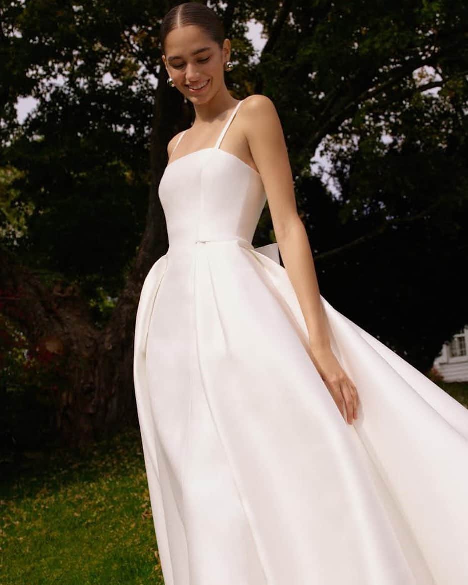 のインスタグラム：「Wes Gordonが描くAW2021 Bridalからの一着は、シルクミカド地を用いたコラムガウンにオーバースカートを重ねたドレス 背中に小さなリボンがついています オーバースカートは、取り外し可能なので、細身のドレスのみでの着用も可能です 2021年春頃の到着を予定しています お問い合わせは、プロフィール欄のメールからお願いいたします  #ノバレーゼウエディング #ノバレーゼドレス #ノバレーゼ #キャロリーナへレラ #プレ花嫁 #花嫁 #ウエディングドレス #結婚式 #novaresewedding #novarese #carolinaherrera」