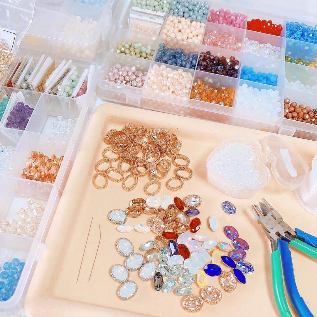 Sakikoのインスタグラム：「マルベリコで人気なビーズリング🌷去年の夏頃から販売をして、嬉しいことに全種類で合わせて700個近く作っておりました😳びっくりです。 色のバリエーションもいつの間にか10種類を超え、minneのギャラリーも華やかさを増しています😊 これからも増やしていく予定です。 : ビーズは、チェコビーズや天然石を使用し中央にはスワロフスキーをはめ込んでいます。 実際に双子で仕入れに行き、どの配色が可愛いかな、お菓子(ビーズリングは全てお菓子の名前がついています🍦🍬🍰)のイメージに合うかなと話しながら選んでいます。 家に帰ったら箱に入れて 制作をしやすいように整頓します。 よく見たらビーズ針が曲がってますね...😳 様々な針を試した結果、このような形が一番やりやすいという結論に至りました💪 ビーズを縫い付ける台座は、金属製を使用することでチェコビーズをより美しく際立たせてくれます。透き通っているチェコビーズほど、それが実感できます✨ 布や樹脂ではなく金属だからこそ、ビーズリングの透明感と台座が反射をおこして、光を放ちます。ぜひ、お持ちの方は太陽光に当ててご覧ください✨ : このように、色々と試行錯誤を重ね完成した作品を、皆様にお届けします✨ これは可愛い！欲しい！と思える双子の直感が一致しなければ没になっちゃいます。(お互い厳しめです😭) 新作を作る週間は、日々プレゼン大会です👩🏻‍🏫」