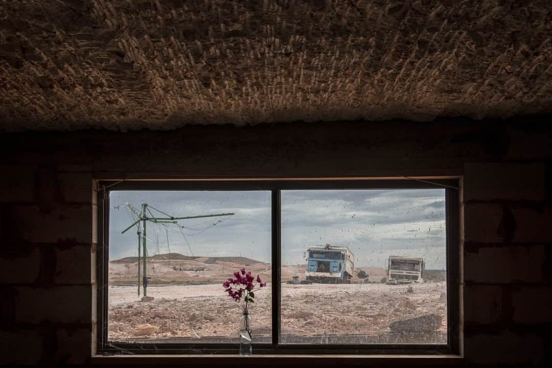 ナショナルジオグラフィックさんのインスタグラム写真 - (ナショナルジオグラフィックInstagram)「Photo by @tamaramerino_photography / Window view from an underground house. Trucks, cars, and old machine scraps dot Coober Pedy´s landscape, waiting to be scavenged and used for spare parts. Coober Pedy is an unconventional town in the Australian outback where most of the population lives in underground houses called dugouts. Life takes place under the vast and lonely land itself, as most residents go after its great wealth of opal, a valuable gemstone. The town of Coober Pedy takes its name from the aboriginal term “kupa-piti,” which translates to “white man hole.” The town is located in an isolated corner of the southern Australian outback, a full 530 miles away from the nearest city.  This photo is part of my series Underland, which documents communities living underground or in cave houses around the world. Follow me on @tamaramerino_photography for more. #caves #undergroundhouse #underland」1月10日 8時36分 - natgeo