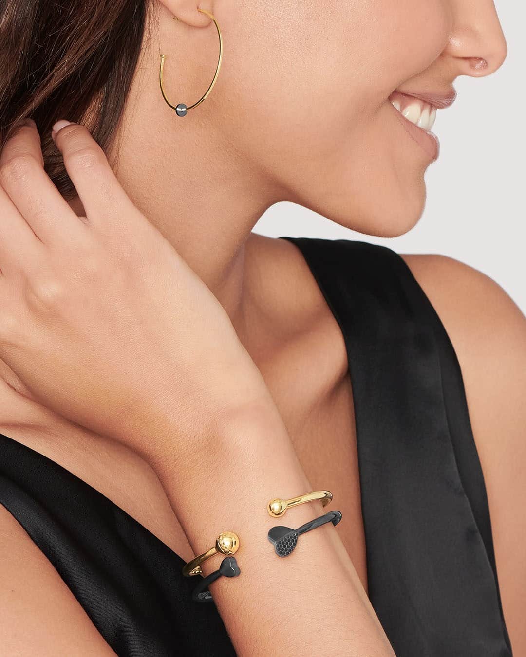 モバードのインスタグラム：「Modernize your jewelry wardrobe with our Movado bangles stacked in black + gold and our signature hoop earrings. #MovadoJewelry」
