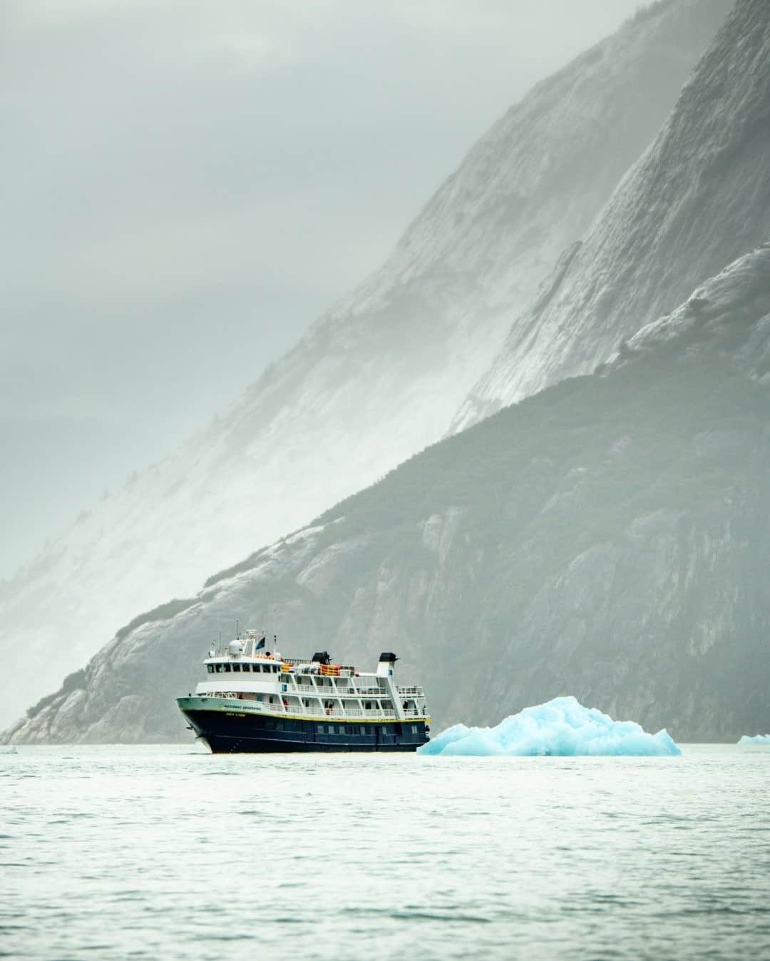 National Geographic Travelさんのインスタグラム写真 - (National Geographic TravelInstagram)「Photo by @jonathankingston / The National Geographic Sea Lion is dwarfed by the massive, glacially cut fjord walls of Endicott Arm in Alaska. It was raining like the clouds were testing the sea to see if they could fill it up. The katabatic winds blowing down off the Dawes Glacier were keeping the ambient temperature just above freezing, and each raindrop felt like a small icy missile exploding on the exposed skin of my face. These memories feel so distant now. If I didn’t have the photos to prove I was there, I could easily be convinced they were all a dream. Where do you dream of exploring in 2021?  Follow @jonathankingston for more images from assignments around the world. #alaska #endicottarm #rain #iceberg #explore」1月12日 0時38分 - natgeotravel