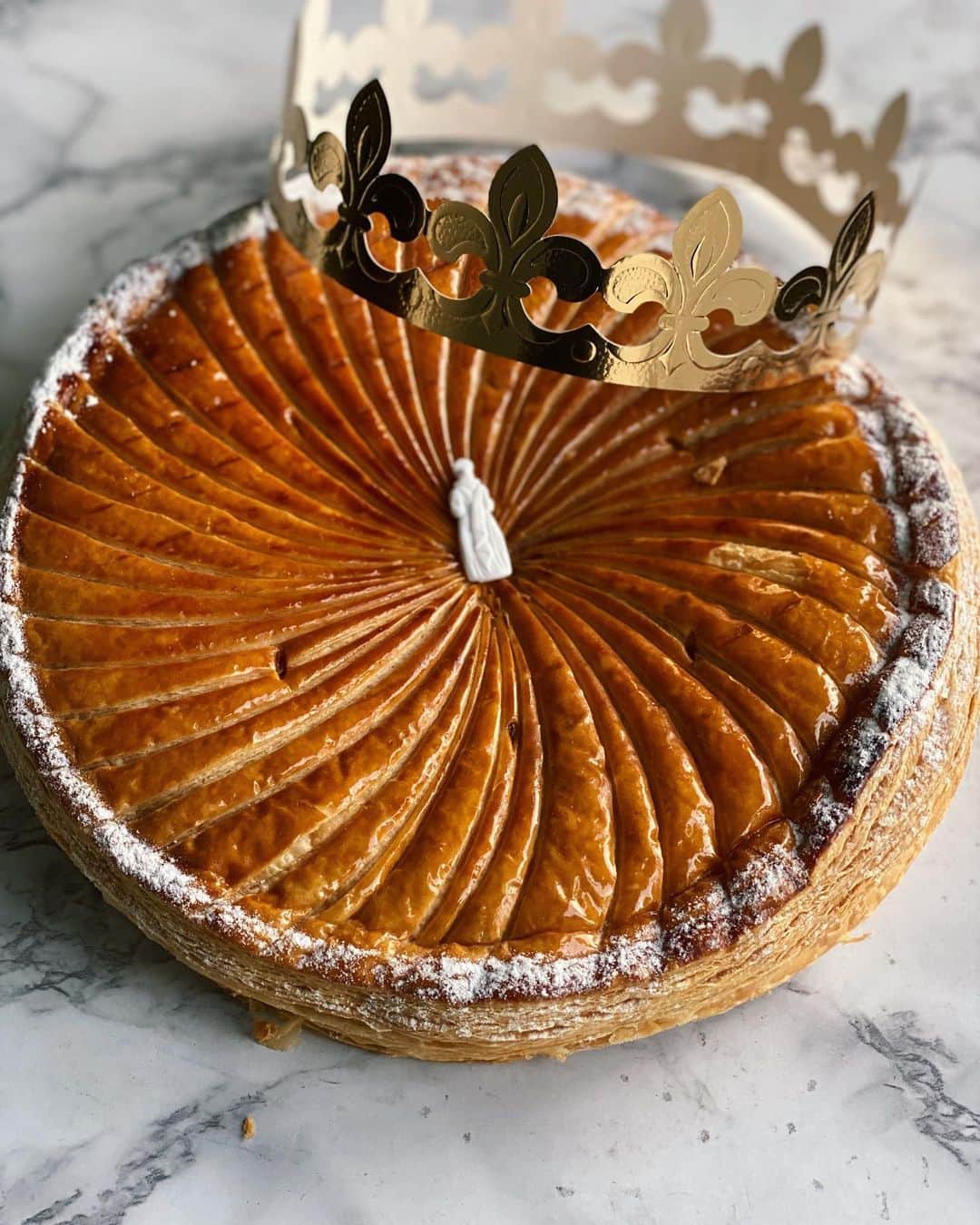 Antonietteのインスタグラム：「The galette des rois, celebrating Epiphany, the day the Three Kings (les rois) visited the infant Jesus, is baked throughout January in France. I was so happy to be able to get it in here in San Diego from  @patisseriebonjour !  The galette is made of puff pastry filled with a frangipani filling with a little charm (fève) baked into it. If you get the charm you get the crown and the right to be king or queen for the day! No need for me to play the game as I already have a crown...on my tooth. 🦷 👑😆 Order ahead of time for pickup or check them out at the North Park Farmers Market. They also have wonderful pastries and croissants!🥐😋」