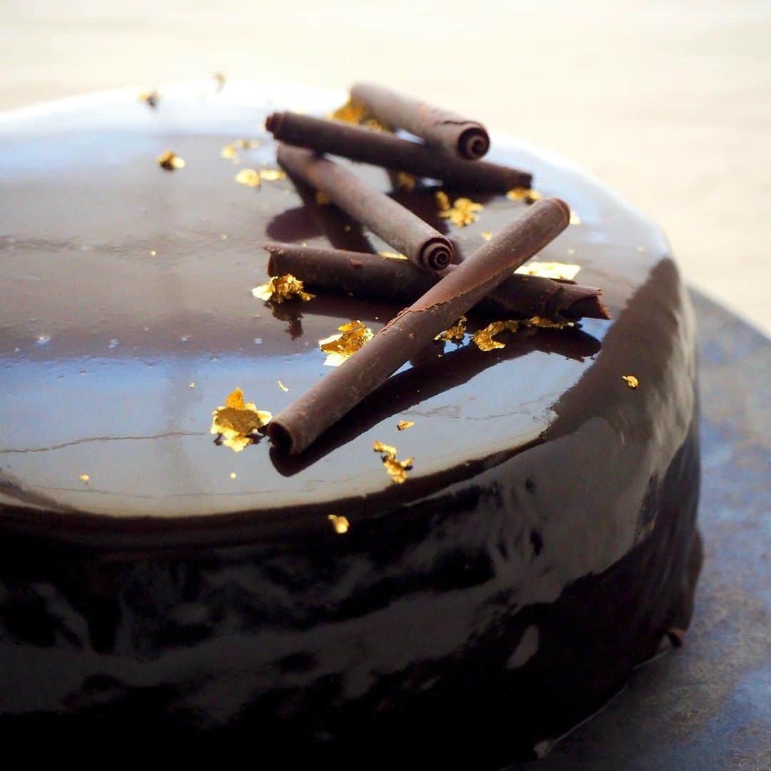 ザッキー☆のインスタグラム：「#グラサージュショコラ   今日は義父の古希祝いへ。 お土産にケーキを作りました✨✨ 昨日の#グラサージュ の完成版です😊  プレゼントなのでカット面はお見せできませんが、 ブランデーコーヒーをスポンジに塗って、コーヒークリームとガナッシュクリームをサンドした4層構造になってます。 味はご想像にお任せしまーーす❣️  角が綺麗に出せずリベンジしたい😂 #ナッペが上手くなりたい  #ザッキーのkitchen  #talk_recipe #暮らしニスタ #フーディーテーブル #おうちごはん #秋冬ほっこりおうちカフェ  #chocolatecake  #チョコレートケーキ #古希 #グラサージュショコラ #70歳おめでとう」