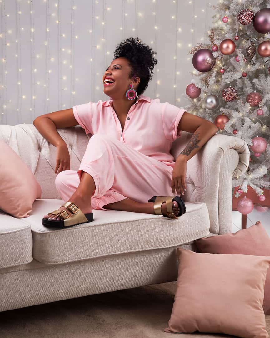 ザクシーのインスタグラム：「Quem aí ama o clima de Natal? A gente sabe que vai ser diferente esse ano, mas ainda assim pode ser um momento especial! O que não pode faltar no seu Natal? #FimDeAnoZaxy  #ZaxyPartner - R$54,99  Compre agora mesmo pelas tags no post, pelo link na bio ou na nossa loja online www.zaxy.com.br  #pracegover #pratodosverem: Na foto, temos uma parede branca ao fundo com luzinhas penduradas. À direita, uma árvore de Natal branca com vários enfeites em tons rosa e rosé. À frente, do lado esquerdo, temos um sofá branco com duas almofadas. Nele, temos uma mulher negra sentada. Ela veste um macacão rosa e a Zaxy Partner na cor dourada nos pés. Esse modelo possui 2 tiras frontais com fivelas reguláveis na lateral.」