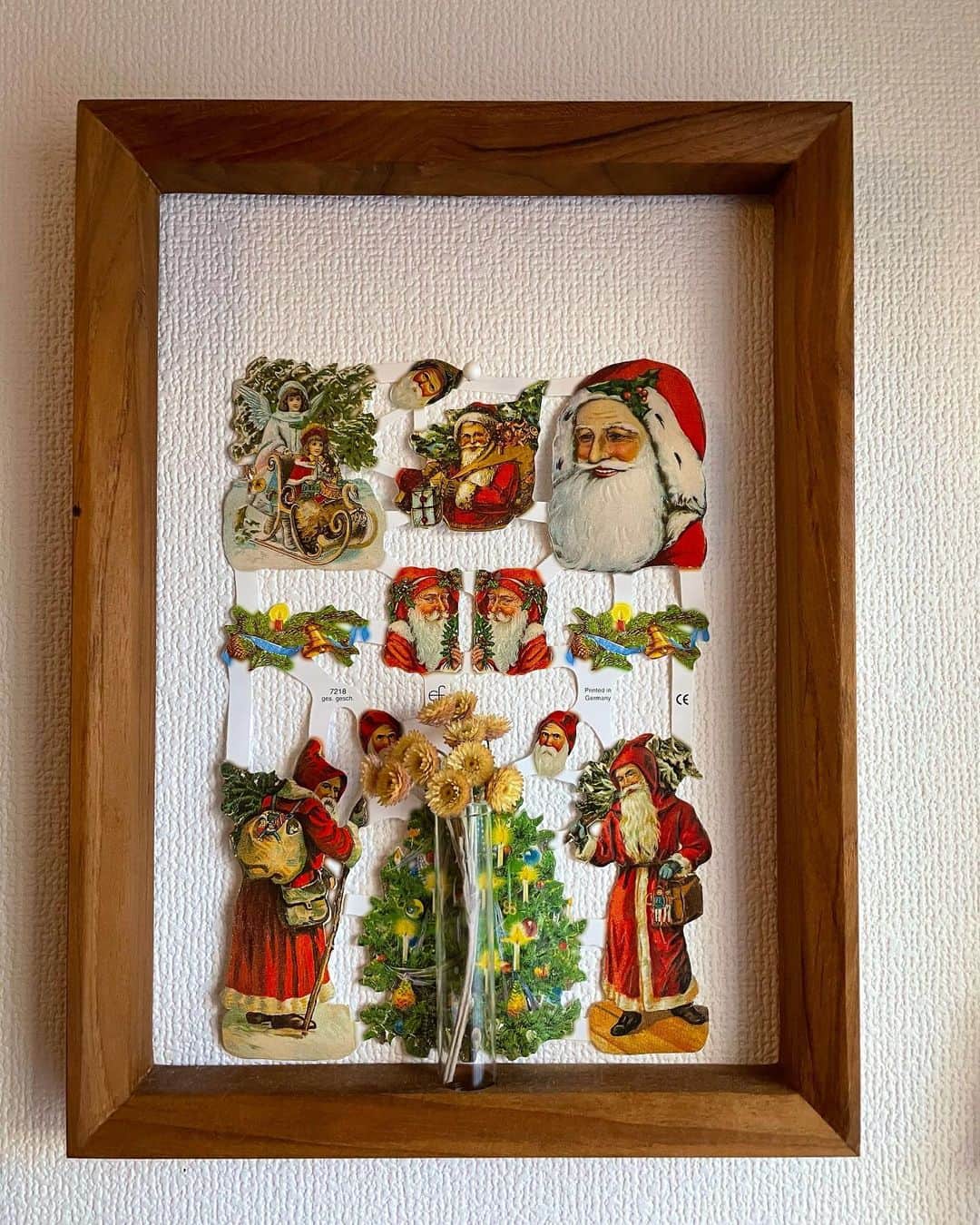 おかもとえみのインスタグラム：「ずっと飾っているお花の額に代官山のクリスマスカンパニーで買ったサンタさんのペーパーアート？を入れ込んでみた🎄✨老人好きにはたまらない表情🥺✨かわいいな〜✨」