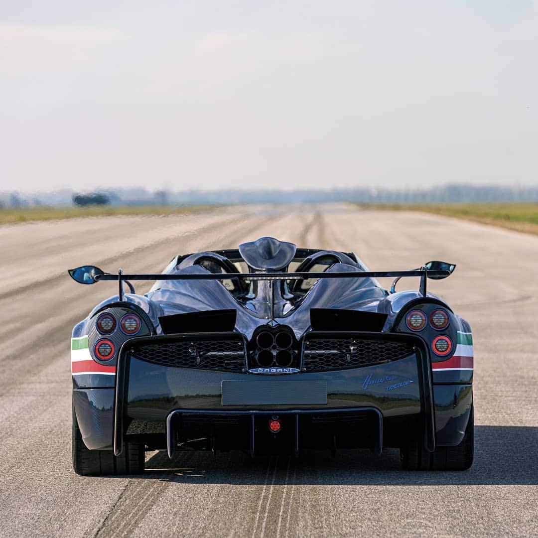 パガーニ・アウトモビリのインスタグラム：「Aerodynamically designed to stick to the ground.  A new, further optimized rear diffuser has been designed to maximize the extraction of air from the underbody.  The new wing, fully integrated with the rear hood with which it forms a single carbon fibre component, allows perfect aerodynamic balance, compensating for the increase in downforce at the front.  Read more on our website or click the link in bio!  #pagani #huayra #huayratricolore #freccetricolori #AeronauticaMilitare #aviation #ItalianAirForce」
