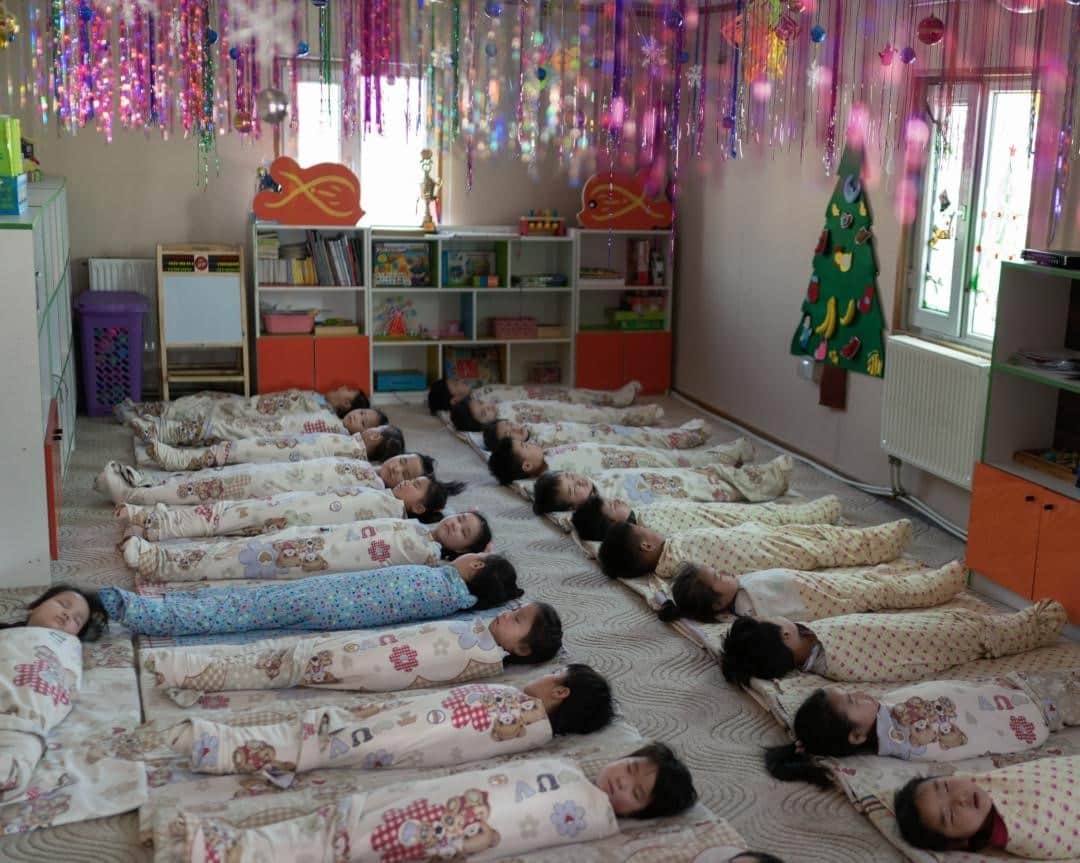 のインスタグラム：「Photo by @hannahreyesmorales / I visited this kindergarten during nap time in Ulaanbaatar last winter. Everything was quiet, except for a mobile phone playing the Buuvein Duu, a Mongolian lullaby, as an air purifier hummed in the background. The kindergarten is located in one of the most air polluted places in the world—that week, the levels were hazardous. The classrooms are one of the only places where they can breathe purified air as they rest. One of the teachers told me that often children from turbulent homes have a hard time sleeping—and she sings lullabies to those children as a way to soothe them and to encourage more needed sleep.  Read our bedtime story, and listen to lullabies in the December issue of @natgeo. Follow me @hannahreyesmorales as we explore nighttime rituals around the world. @timstrust @insidenatgeo #Mongolia  Check out Nat Geo's IG Story and link in bio for more.」