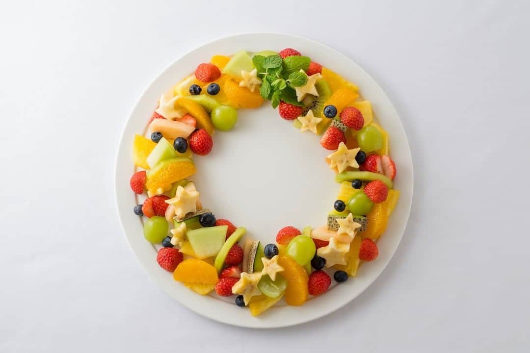 Dole_jp ドール ジャパンのインスタグラム：「子どもも大人も大好きなフルーツで作る、食べておいしいクリスマスリース🎄 お好みのフルーツを使って、親子クッキングもおすすめです✨ ． ． 本日ご紹介するレシピはこちら！ ▼▼▼ 【バナナで作るクリスマスリース】 ． ． ✏材料（4人分） ． ・パイナップル　1/4個分 (100g) ・バナナ　1本 ・グリーンキウイ　1個 ・ブルーベリー　15粒 ・メロン　1/10個 ・赤肉メロン　1/10個 ・ぶどう　5粒 (マスカットでも可) ・いちご　8粒 ・オレンジ　1個 ・ミント　適量 ． ． ✏作り方 1. パイナップルは5mm厚さのくし形切りにする。バナナは輪切りにし、星型で抜く。 ． ． 2. キウイは皮をむき、半月切りにする。ぶどう、いちごは縦半分に切る。 ． ． 3. オレンジは皮をむき、房の薄皮と実の間に包丁を入れて果肉だけを取り出す。 ． ． 4. メロンは皮つきのまま、赤肉メロンともども5mm厚さのくし形切りにする。 ． ． 5. 皿にパイナップル、キウイ、メロン、赤肉メロンをリース状になるように並べ、いちご、マスカット、ブルーベリー、バナナ、オレンジをバランスよく散らす。 ミントはトップスターのように一か所にまとめて飾る。 ． ． カットフルーツを使えば、もっとお手軽に作ることができますよ🎵 ． ． #ドール #Dole #フルーツ #バナナ #パイナップル #キウイ #クリスマスリース #クリスマスレシピ #クリスマス料理 #クリスマススイーツ #ヘルシー #カフェご飯 #レシピ #今日のおやつ #うちカフェ #おうちcafe #簡単レシピ #スイーツ部 #お菓子作り好きな人と繋がりたい #親子クッキング #親子の時間 #banana #pineapple #instafood #fruits #foodie #recipe #cooking #delistagrammer」
