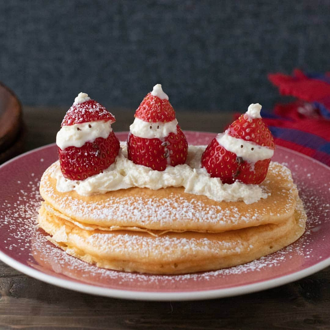 ザーネワンダー公式Instagramのインスタグラム：「レシピあり🍓🎅 「イチゴサンタのパンケーキ」の作り方 * クリスマスにぴったりなイチゴサンタをのせたパンケーキです😆❤️ イチゴとホイップクリームで簡単にできるサンタを ぜひ一度お試しください♪ * 今回のレシピは、 @moaiskitchenさんに作ってもらいました！ * [モアイズキッチン さんからのワンポイント] パンケーキの生地は混ぜすぎると膨らみにくくなるので、 ホットケーキミックスを加えた後はさくっと混ぜてください🙋いろんな表情のサンタさんを作って楽しんでくださいね♪ * ぜひ参考に作ってみてくださいね！ * * 「イチゴサンタのパンケーキ」 * 【材料】 ホットケーキミックス… 1袋 卵…2個 牛乳…100ml いちご…適量 ザーネワンダーホイップクリーム…適量 チョコペン…適量 粉糖…お好みで メープルシロップ…お好みで * * 【作り方】 ①牛乳と卵をボウルに入れ、泡立て器で混ぜたら、ホットケーキミックスを加えてさくっと混ぜる。 * ②フライパンを熱し、一度濡れふきんで粗熱をとり、1をおたま1杯分加えて弱火で加熱する。 * ③表面がポツポツとして乾いてきたら、フライ返しで裏返し、中まで火が入るまで弱火で焼く。生地がなくなるまで繰り返す。 * ④いちごのヘタは切り落とし、先端から1/3くらいのところで切る。いちごの太い方を下にし、断面にザーネワンダーホイップクリームを絞り、先端のいちごをのせる。先端にザーネワンダーホイップクリームを絞り、チョコペンで顔を書いて、イチゴサンタを作る。 * ⑤焼き上がったパンケーキを重ね、ザーネワンダーホイップクリームを絞り、イチゴサンタをのせる。仕上げに粉糖やメープルシロップをかける。 * * #ザーネワンダー #ホイップクリーム #生クリーム * #今日のごはん #手作りごはん #簡単レシピ #おかず #レシピ #食卓 #節約 #献立 #家庭料理 #節約生活 #自炊 #ランチ #家ごはん #時短レシピ #簡単レシピ #おいしい #料理 #美味しい #おうちごはん #手作り料理 #手料理 #料理好きな人と繋がりたい  #スイーツ好きな人と繋がりたい #パンケーキ #クリスマスレシピ #デコスイーツ」