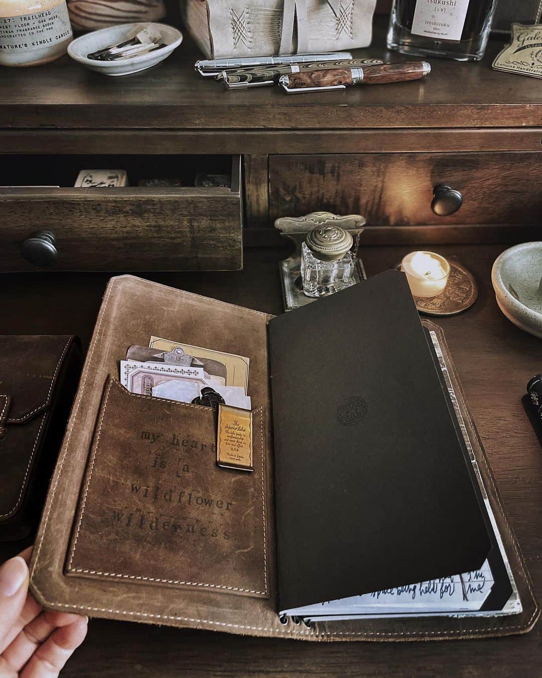 Catharine Mi-Sookさんのインスタグラム写真 - (Catharine Mi-SookInstagram)「More light etching into our days with the arrival of yesterday’s solstice. A theme I’ll walk with into the dawn of a new epoch, a theme I’ll embrace full hearted today. So many juggles and layers and loads weighted on countless shoulders and hands. I hope that in between the crevice of moments there would be the warmth of sunshine for sweet sustenance of the soul. And I hope for brighter chapters ahead with many blooms and sights to behold along the terrain for all. . . . . . Boot Brown Leather Vagabond Notebook & Three Penvelope Case @franklinchristoph. Baoshi Soyouz Fountain Pen in Amber @recifeparis. Ceramic #mypitchpine Candle Holder & Wolf Incense Burner @pitchpinepottery. Leather Journals w/ Handwoven spines @loombound. . . . . . #onmydesk #vagabondnotebook #franklinchristoph #journaling #recifeparis #recife #fountainpen #fountainpens #writinginstruments #travelersnotebook #darkacademia #darkacademiaaesthetic #deskgoals #booksandcandles #stillswithstories #hyggestyle #capturequiet #cozycorner #darkandlovely #darkandmoody #myquietbeauty #smallmomentsofcalm #documentyourdays #loveforanalogue」12月23日 0時13分 - catharinemisook