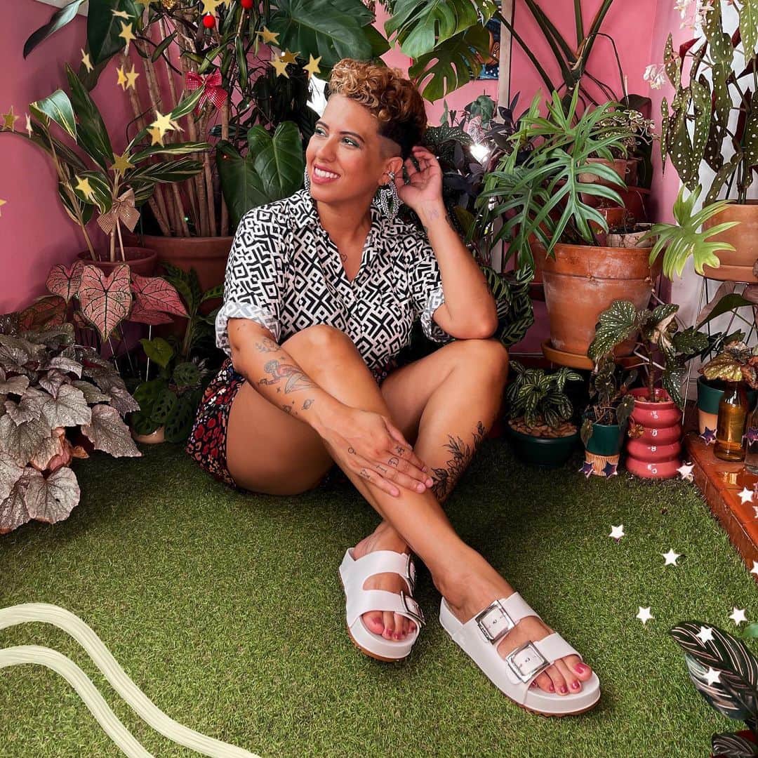 ザクシーのインスタグラム：「O que você vai fazer diferente em 2021? Nós convidamos a @carlinha pra falar sobre seus desejos pro próximo ano e queremos perguntar pra vocês: Vocês são gentis com vocês mesmas na hora de traçar as metas pro ano seguinte? Esse ano já foi tão difícil pra todo mundo, que tal se ao invés de metas engessadas e numéricas pro ano que vem a gente fizesse metas palpáveis e pensando na nossa alegria? Corre lá no perfil dela pra conferir algumas dicas pra viver esse ano de uma forma mais leve e com menos pressão #FimDeAnoZaxy  #pracegover #pratodosverem: Na foto 1, temos o fundo rosa com vários vasos de plantas espalhadas. No centro, temos a @carlinha, vestindo uma camisa, um shortinho estampado e a Zaxy Partner na cor branca nos pés, um modelo de sandália que possui duas tiras frontais com fivelas laterais. Na foto 2, temos  o fundo rosa com alguns quadros na parede. No centro, temos a @carlinha vestindo uma blusa neon, um casaquinho rosa e shortinho estampado. Nos pés, ela calça a Zaxy Way Papete na cor branca, um modelo de sandália que possui duas tiras frontais e o fechamento traseiro.」