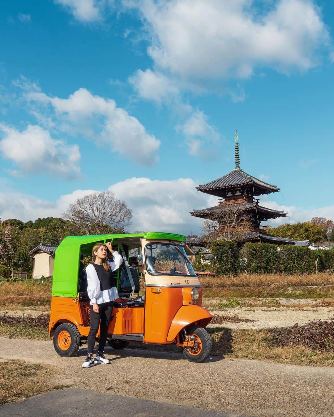 Koichiのインスタグラム：「.  Riding a Tuk-Tuk @ Nara’s local area 🛺💨  ワーケーションの楽しみ方のひとつに、滞在地周辺の町を散策してみることがあります。 信貴山を下りて斑鳩町（いかるがちょう）へ。この辺りには、長閑な里山の風景と世界遺産の法隆寺などがあって、散策にはもってこいの場所。 この日はドライバー付きのトゥクトゥクをチャーターして、ワーケーション仲間のアラマリちゃん @marina_k_araki と2時間のドライブデート 笑  1st / 世界遺産に登録されている法起寺。長閑な風景の中に国宝の三重塔がポツンとあって、とてもフォトジェニックな場所。  2nd / 和カフェ布穀薗（ふこくえん）。歴史的建造物を利用したカフェで、斑鳩名物の竜田揚げランチが美味しいですよ。  3rd / 法隆寺の近くで斑鳩神社に寄り道。トゥクトゥクはちっちゃいから、ちょっと寄り道がしやすいのがいいな。  4th / 法起寺周辺の畑の中をドライブ。この辺りは秋には一面のコスモス畑になります。  #信貴山ワーケーション #奈良 #信貴山 #斑鳩 #SAGOJO  Special thanks @waikaru.ikaruga @fukokuenikaruga .」