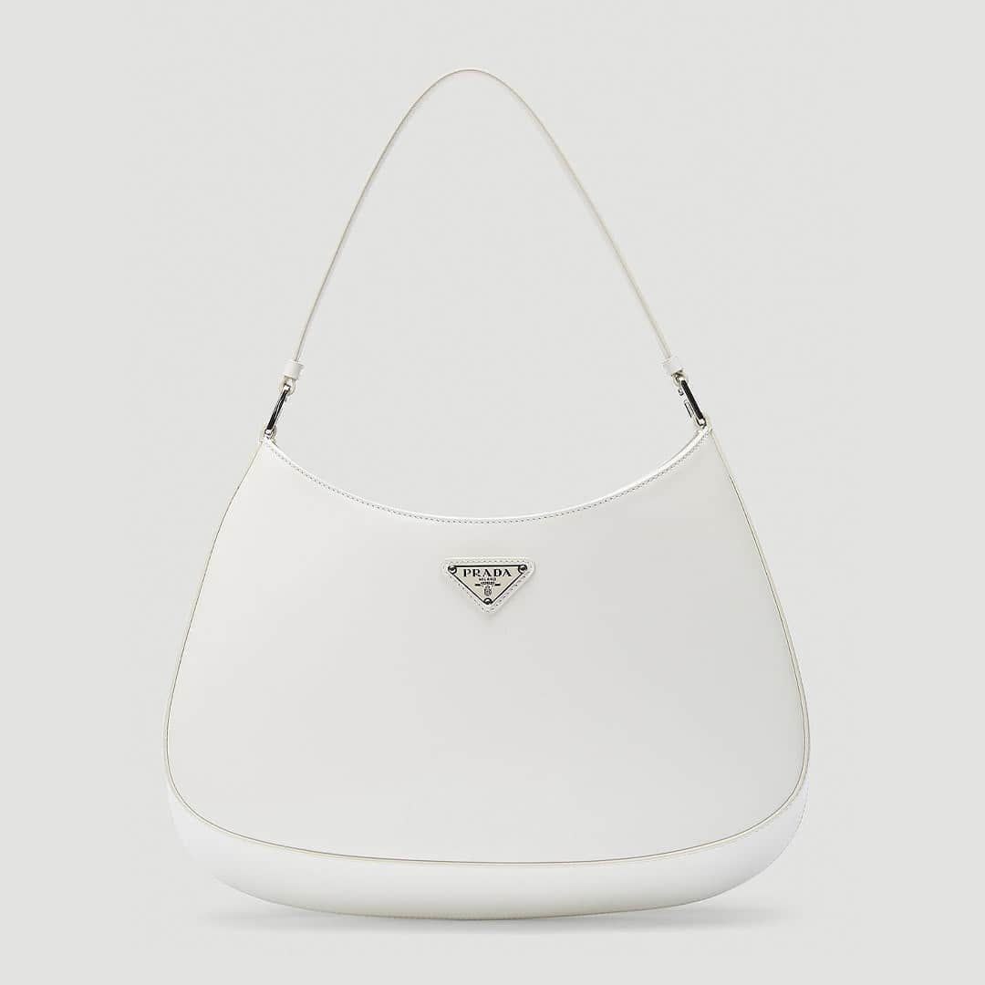 エルエヌシーシーのインスタグラム：「Prada presents the Cleo Shoulder Bag, inspired by the fashion house’s minimalist silhouettes of the 90s. As seen on editors and influencers alike, the sleek design is emphasised by the sloped construction. @prada」