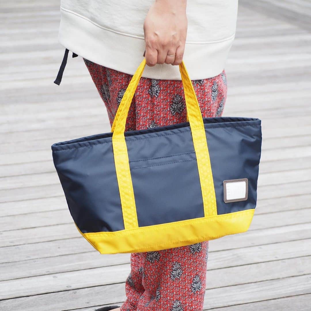 B JIRUSHI YOSHIDAのインスタグラム：「【Recommend Item】 PORTER × B印 ヨシダ (GS) / 2トーン トート S ・ キャンバストートによく見かける仕様を軽量素材で表現したコンパクトトートバッグ。 男女問わずに取り回しやすいサイズ感で、旅行先での街歩きはもちろん、ちょっとしたお出かけやランチタイムバッグとしてもおすすめ。 ・ フロントのスリット収納は、スマートフォンや財布などすぐに取り出したいものを入れておくのに便利。メイン収納上部はジップ仕様になっており、中身が濡れたり落下するのを防ぐほか、セキュリティ面も安心です。  素材の特性を活かして、使わない時は折りたたんでバッグに収納しておくのもおすすめ。  ・ PRICE : ￥14,000+ TAX COLOR : BLACK*CHARCOAL.G・KHAKI*GREY・NAVY*YELLOW  ※現在B印ヨシダ成田空港第1ターミナルは営業終了の為、こちらのアイテムはビームスオンラインショップ、又はB印ヨシダ代官山、BEAMS各店へのお取り寄せ対応にて購入いただけます。 . #bjirushiyoshida#B印YOSHIDA#BEAMS#ビームス#yosidakaban#吉田カバン#ポーター#porter#비지루시요시다 #도쿄 #다이칸야마#빔스 #빔즈#포터#데일리룩 #YOSHIDAlineup#naritaairport#成田空港#travel#旅行#madeinjapan#tokyo#exclusive」