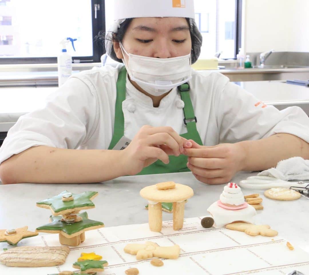 神戸製菓専門学校（公式）さんのインスタグラム写真 - (神戸製菓専門学校（公式）Instagram)「🎅クリスマス工芸菓子🎄 昼1年制学科の学生たちがみんなで協力して作り上げた #工芸菓子 ✨✨✨  クッキーやマジパンを使って作り上げた超大作です❗️👏  お花や動物たちは #マジパン という砂糖とアーモンドを挽いて練り合わせたものです✨😮  お家は見ての通りクッキーですね🍪😄  雪の積もり方や、お料理やプレゼントボックスなど、演出が本当に細かい💕😊  実は他にも、おうちの裏側にクラスメイトのイニシャルが入ったエプロンが干してあったり✨👀 家の中にいる人は在校生ならもちろん誰だかわかるはず💡😊  皆さん、素敵なクリスマスイブを♫  #神戸製菓　#神戸製菓専門学校　#製菓　#パティシエ　#お菓子作り　#お菓子作り好きな人と繋がりたい #クリスマス #クリスマスプレゼント　#サンタさん　#クリスマスツリー　#ヘキセンハウス #お菓子の家 #クリスマスお菓子 #神戸 #三宮　#製菓専門学校　#パティシエの卵 #pattistagram2020」12月24日 9時50分 - kobeseika_info