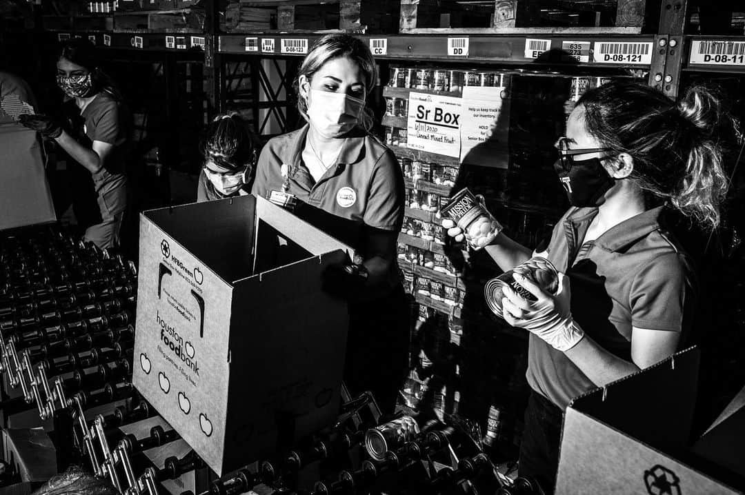 National Geographic Creativeのインスタグラム：「Photo by Graham Dickie @instadickie / A morning scene inside the warehouse at the Houston Food Bank's headquarters. Workers use forklifts to retrieve large palettes of food and drinks and place them by short assembly lines, where volunteers work in concert to package items for distribution. When the coronavirus struck, the food bank soon began distributing more than double the amount as the same time last year; by autumn the volume had fallen somewhat, but still exceeded one million pounds of food per day.  I recently spent several days in Houston photographing the many ways folks there are tackling food insecurity—looking at big institutions like the Houston Food Bank and small ones, like a neighborhood thrift shop in the Third Ward neighborhood that had installed a community refrigerator outside its doors. Their different approaches served different population groups across the city's sprawl (the Houston metro area, home to around seven million, is one of the most diverse in the country) and attested to the need for both small, grassroots initiatives and large-scale ones.  @FeedingAmerica is the nation’s largest hunger-relief organization with a network of 200 food banks and 60,000 food pantries and meal programs that together provide food to more than 40 million people per year. Learn more at feedingamerica.org/FeedTheLove. #FeedTheLove」