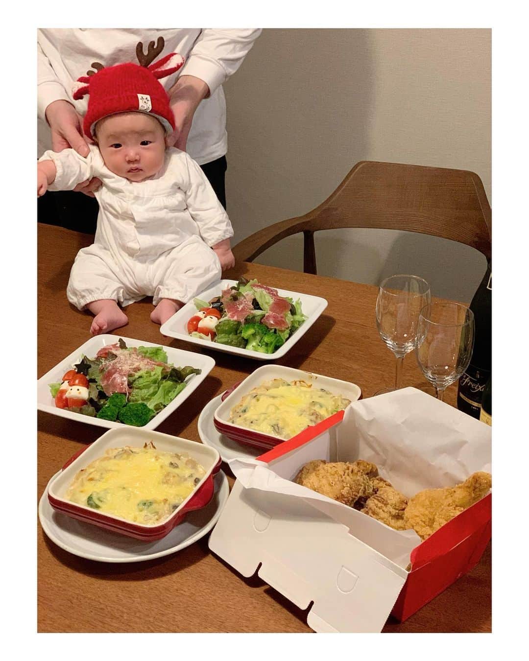 のインスタグラム：「おうちでメリークリスマス🎄  生ハムサラダに愛嬌あるぶさかわサンタを添えて🥗シェフのお気に入り広島牡蠣のグラタン🦪ケンタッキーは人多すぎるからモスチキン🍗乾杯🥂  #クリスマス#新米ママ#生後2ヶ月#赤ちゃんのいる生活」